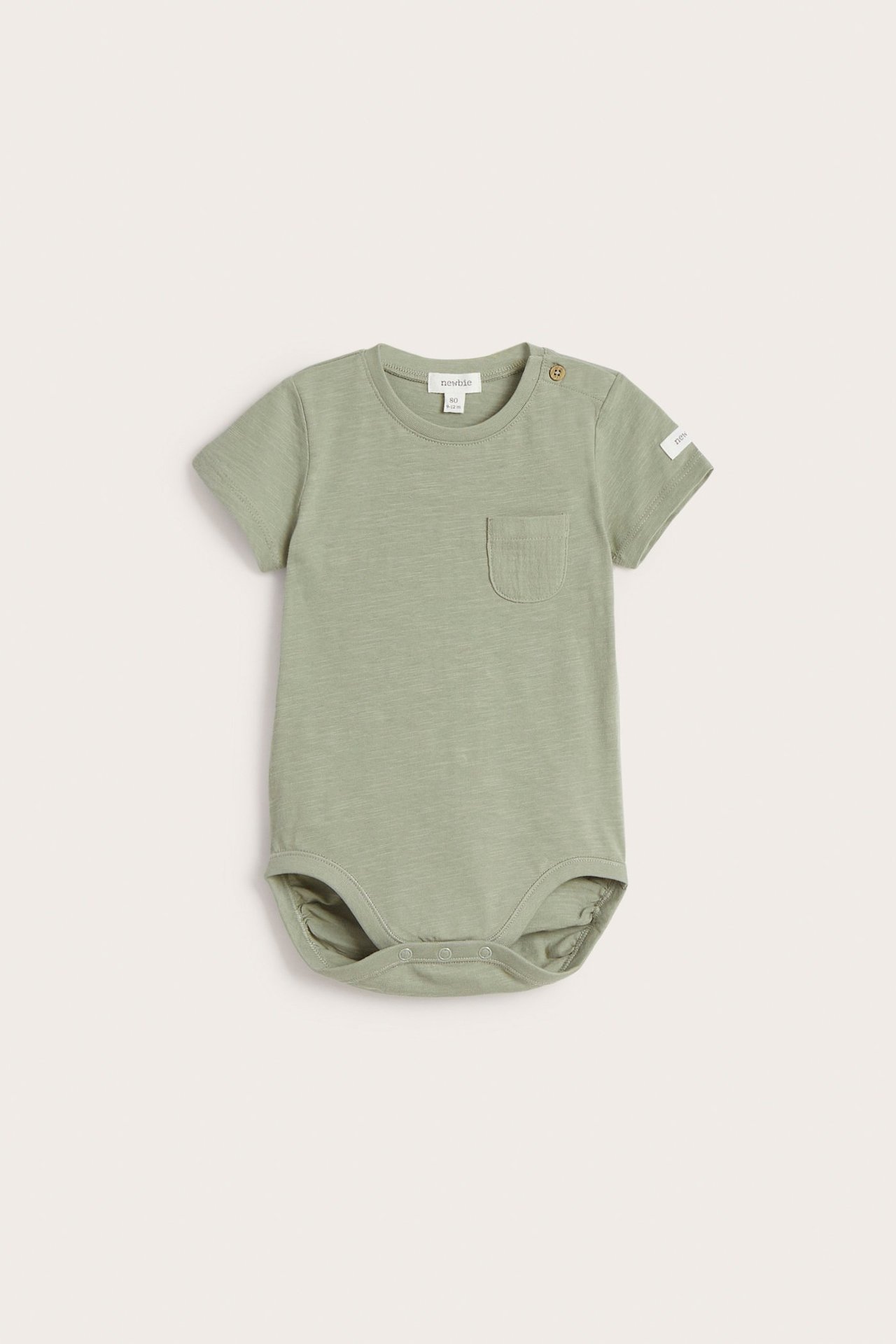 Front view: baby's green short-sleeved cotton bodysuit with shoulder and crotch snap buttons, chest pocket.