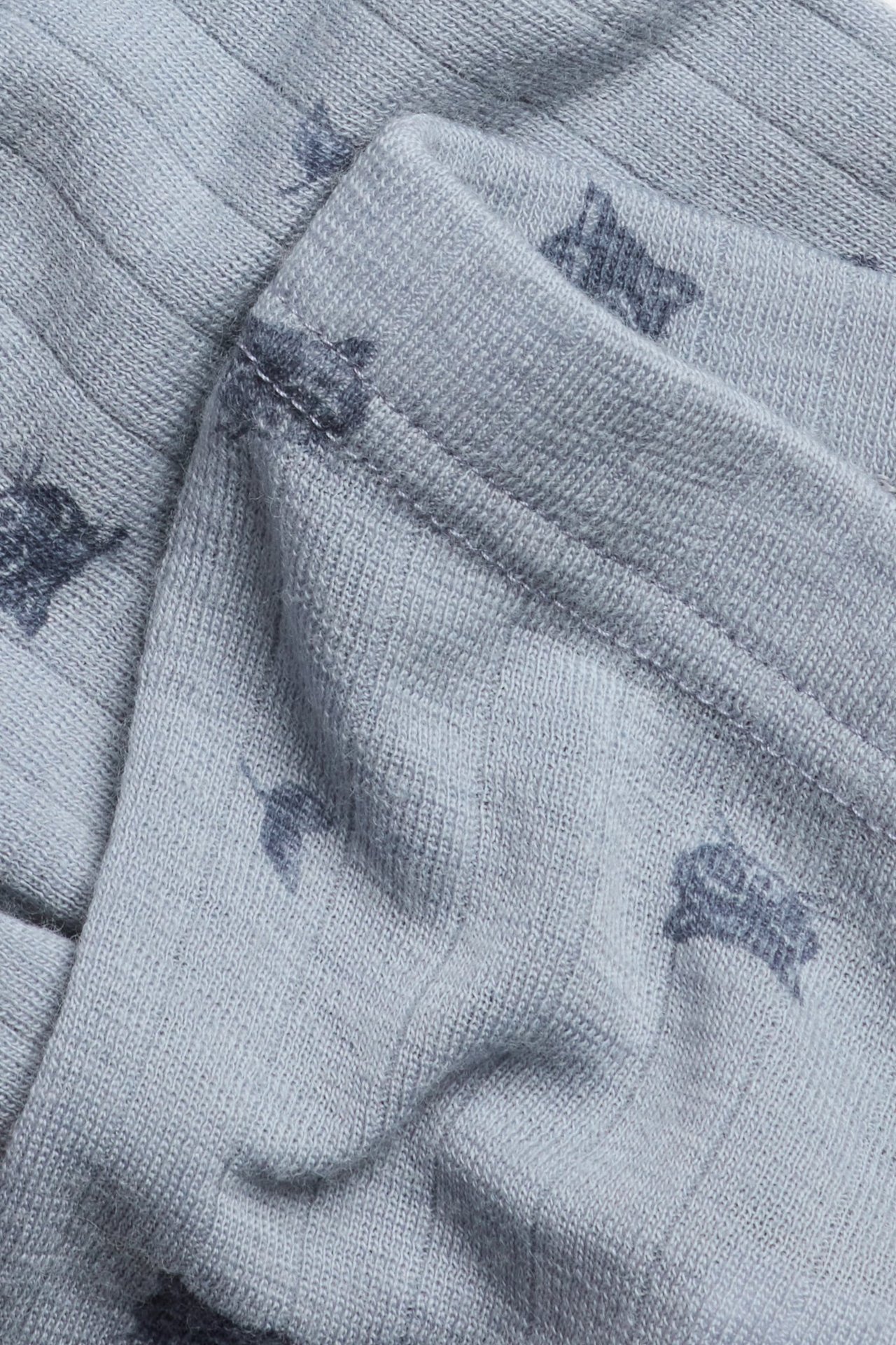 Nahaufnahme von hellblauen gerippten Merinowoll-Leggings mit dezentem Tiermuster.