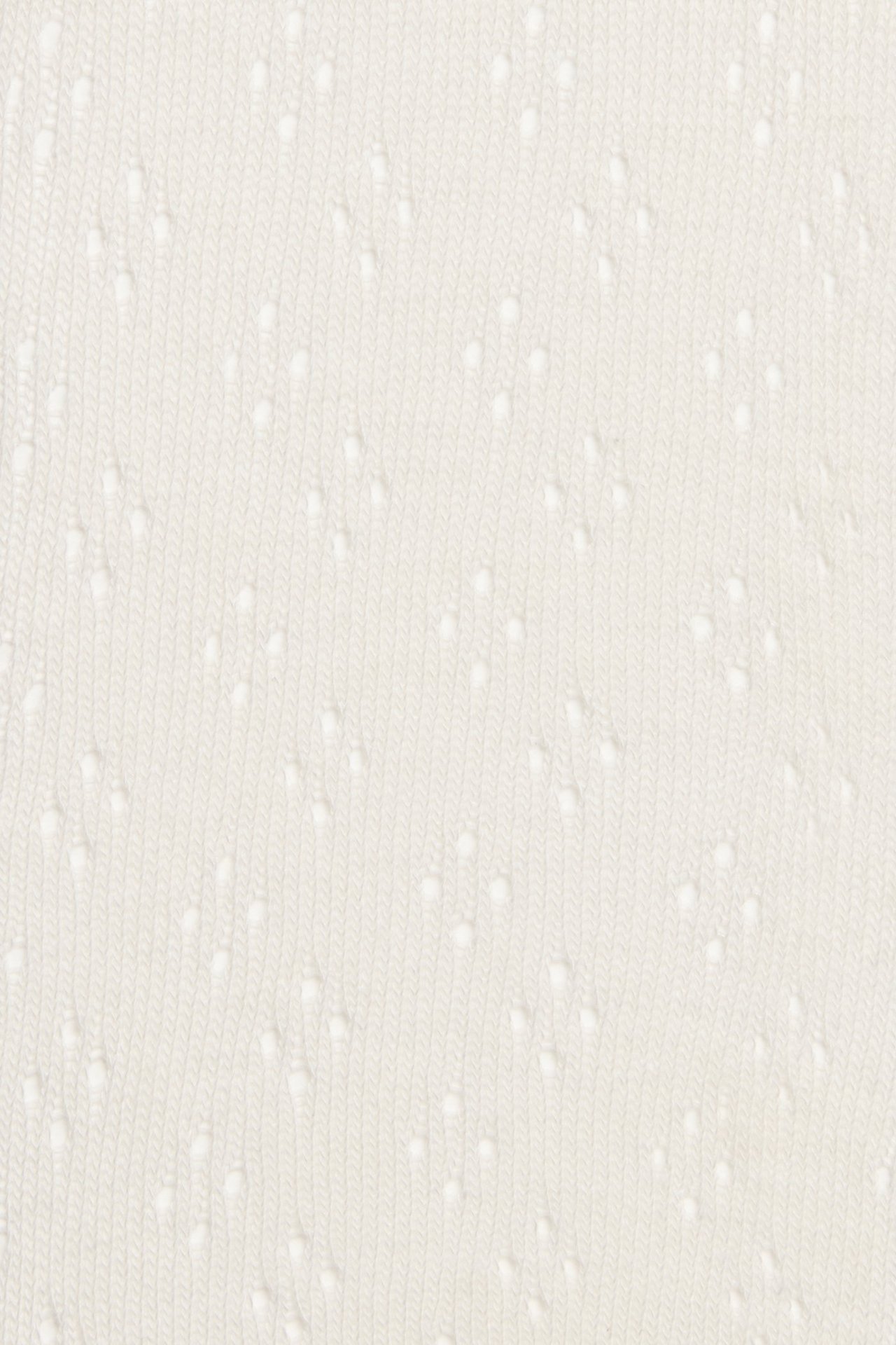 Nahaufnahme von cremeweißem Strickstrumpfhosenstoff mit dezentem Lochmuster.