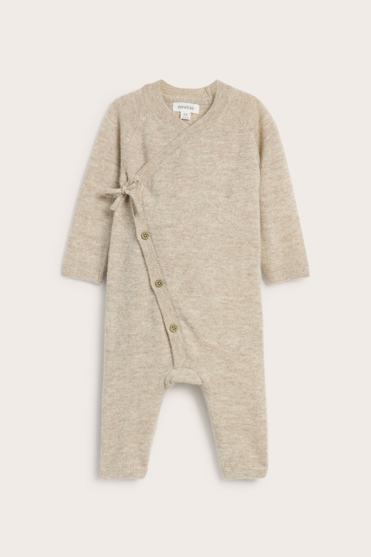 Front view of a beige melange smooth knit baby wrap jumpsuit with side tie and buttons.