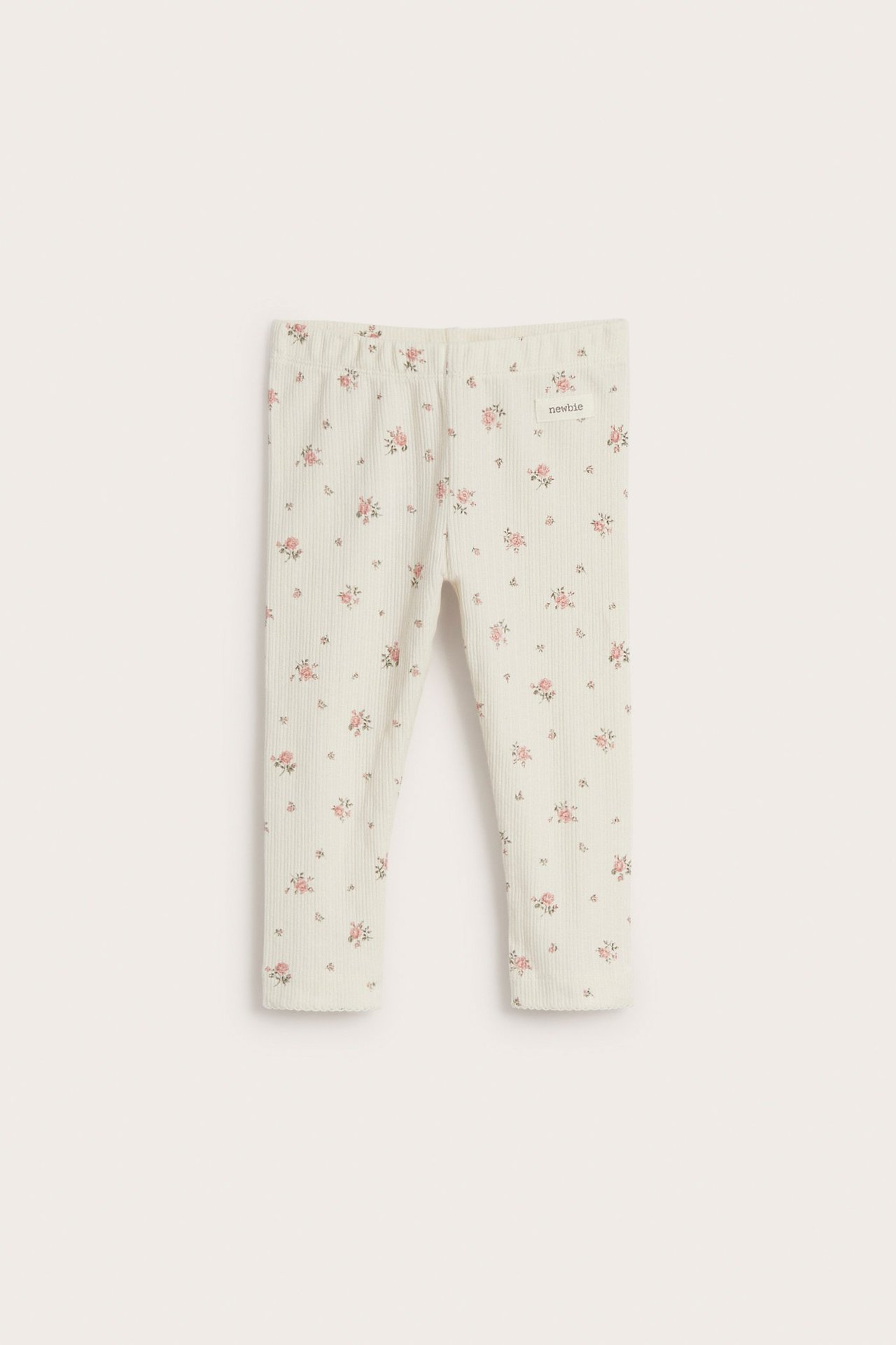 Vorderansicht: Off-white gerippte Baby/Kinder Leggings mit rosa Blumenmuster und Gummizugbund.