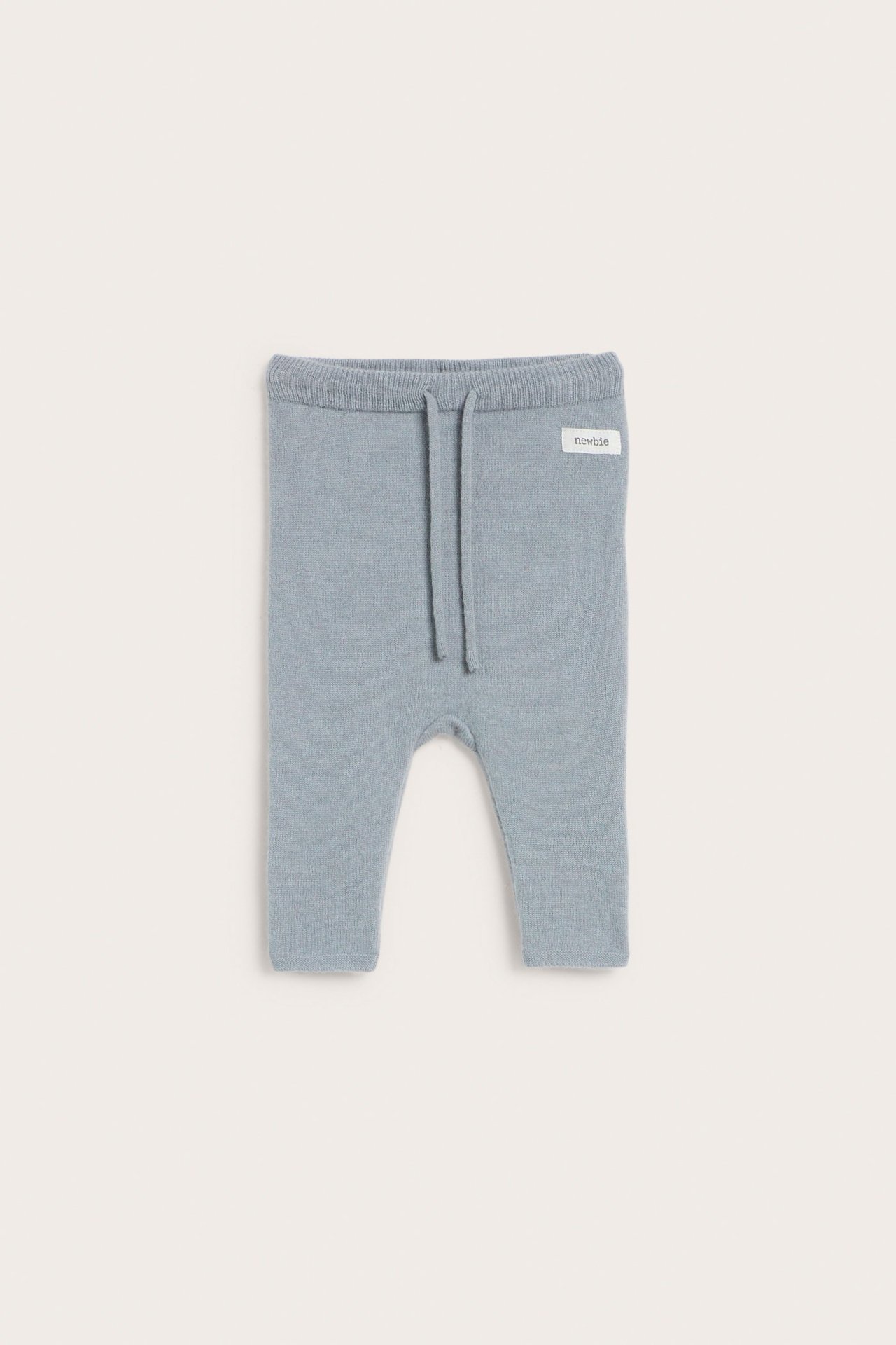 Front view of light blue plain knit baby pants in wool-cashmere blend with elastic waist and drawstring.