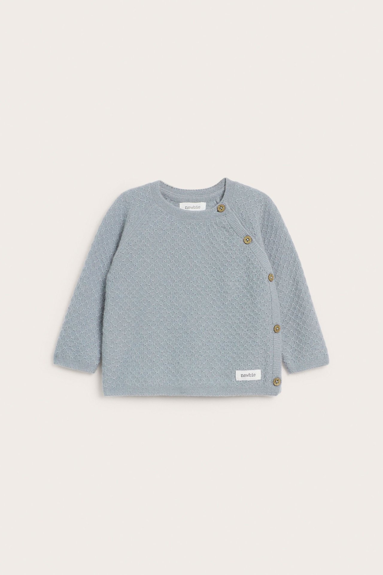 Front view of a baby's light blue textured knit wool-cashmere cardigan with side button fastening.