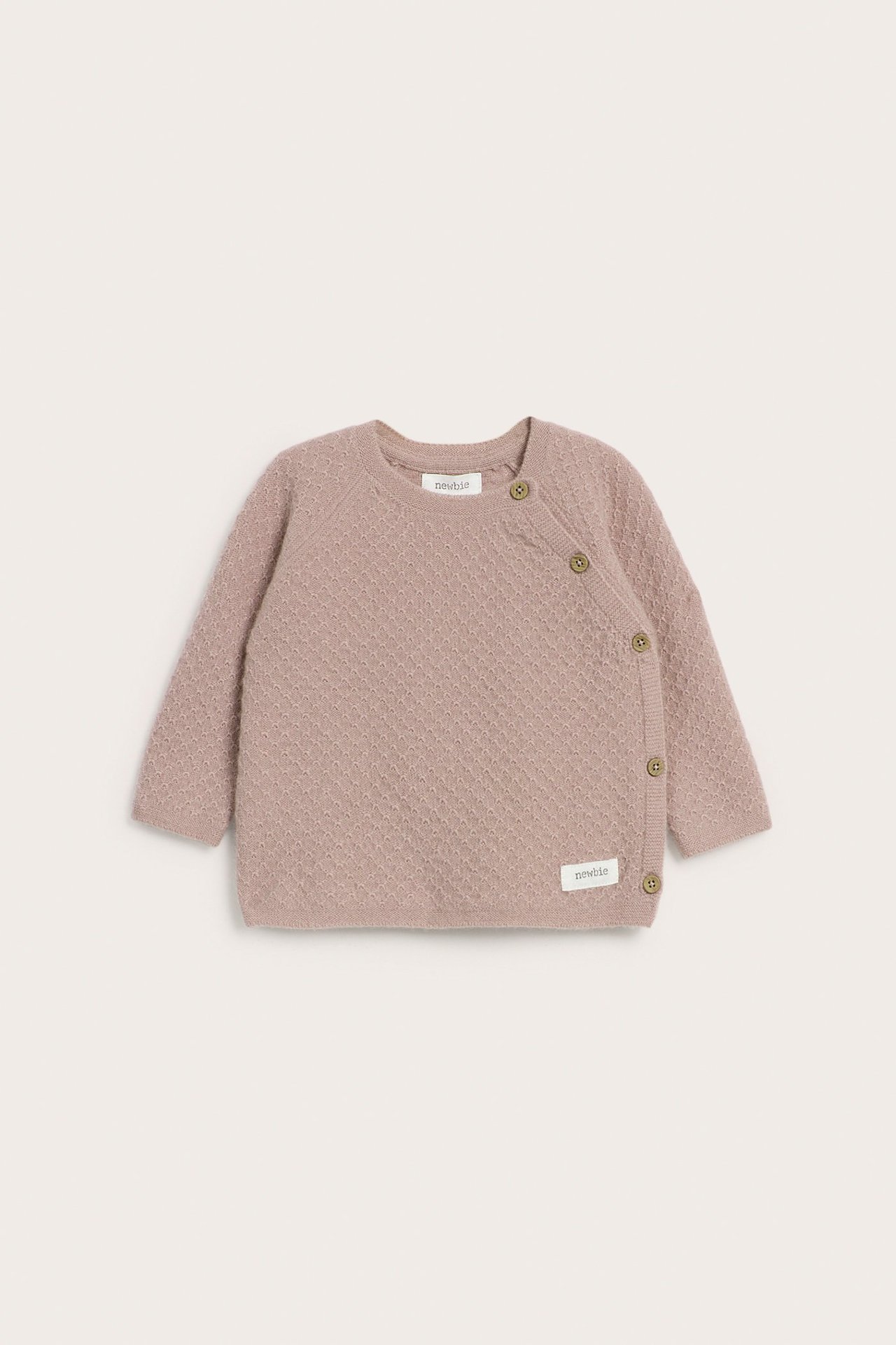Front view of a baby's pink textured knit wool and cashmere blend cardigan with side button fastening.