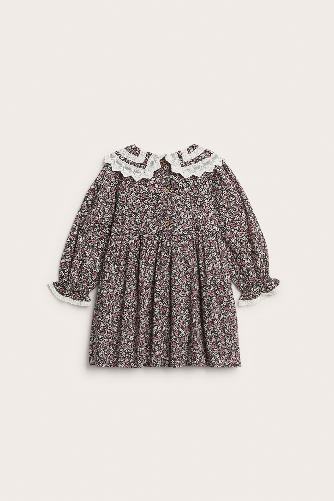 Vorderansicht: Schwarzes geblümtes Baumwollkleid für Kinder mit weißem Spitzenkragen, Puffärmeln und Knöpfen vorne.