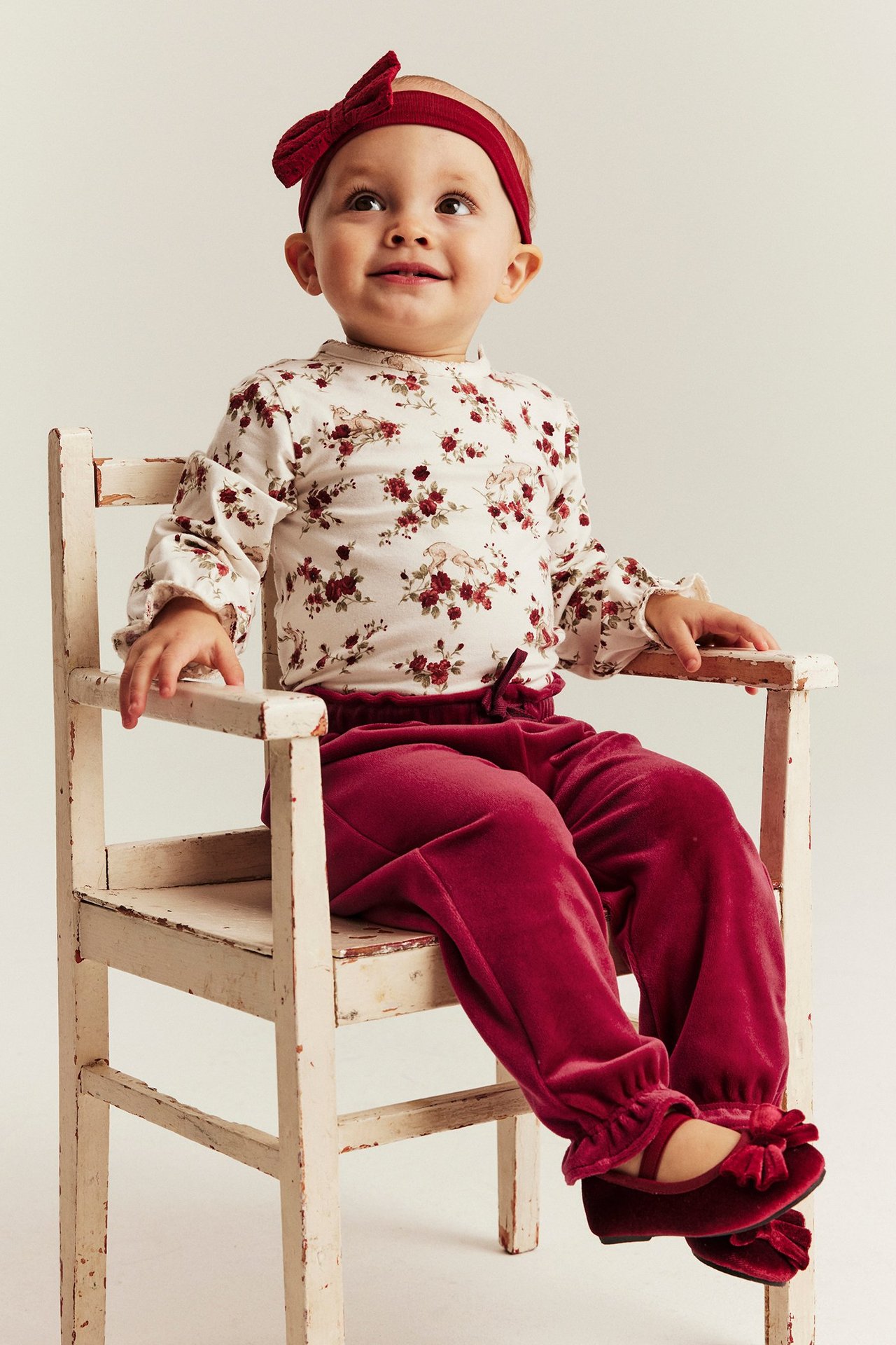 Child in red velour joggers with elastic waist and ankle, front view.