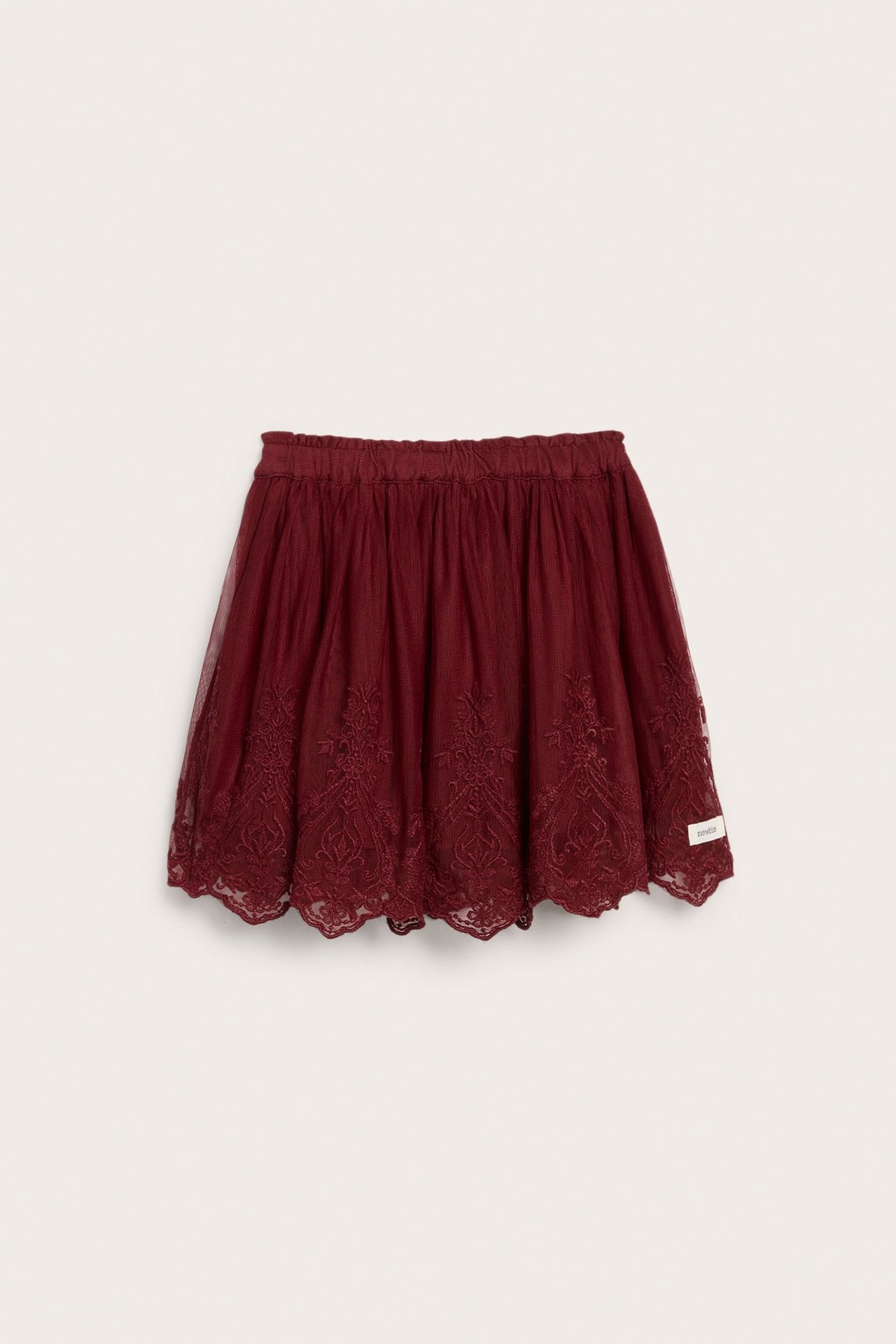 Front view of a dark red mesh skirt with an elastic waist, ornate embroidery, and a scalloped hem.