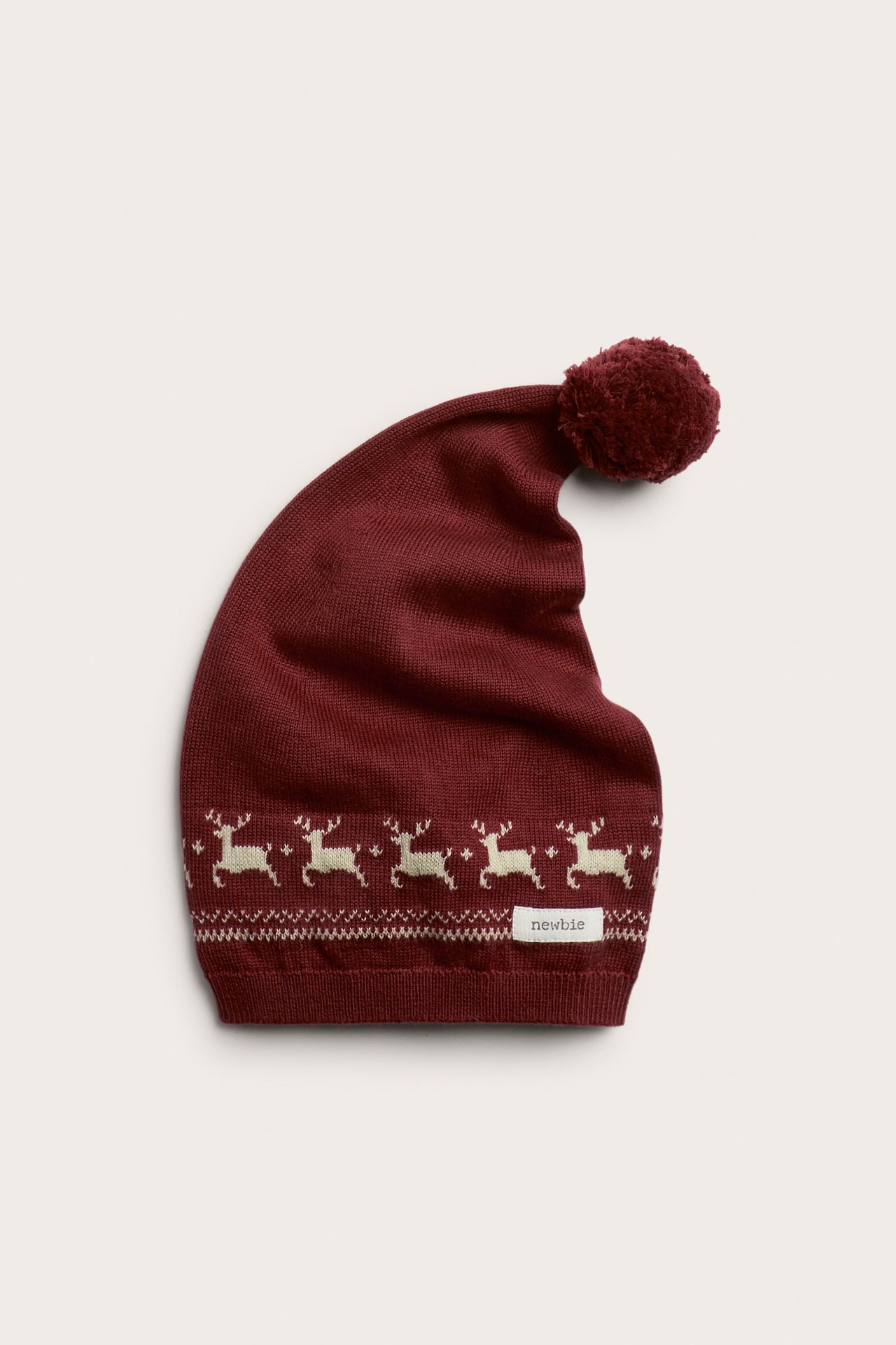 Rote Baumwoll-Nikolausmütze mit weißem Rentier-Jacquardmuster und passender Bommel, Frontansicht.