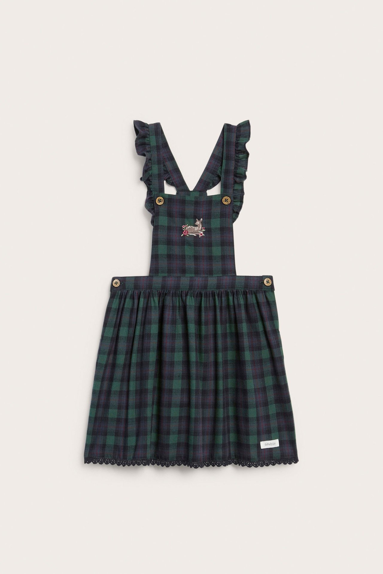 Front view of a kid's blue and green plaid cotton dungaree dress with ruffled straps and deer embroidery.