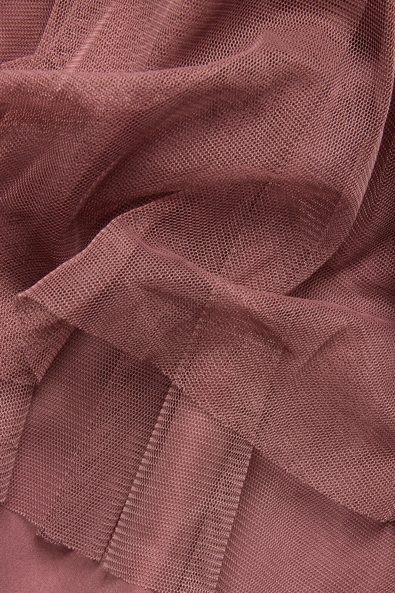 Close-up of dark pink mesh fabric, showing its fine net texture and soft folds.