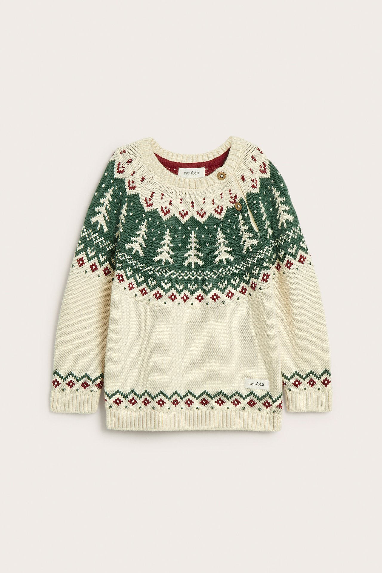 Vorderansicht: Kinder-Offwhite-Strickpullover aus Baumwolle mit grünen Tannenbäumen, rotem Jacquardmuster und Schulterknöpfen.