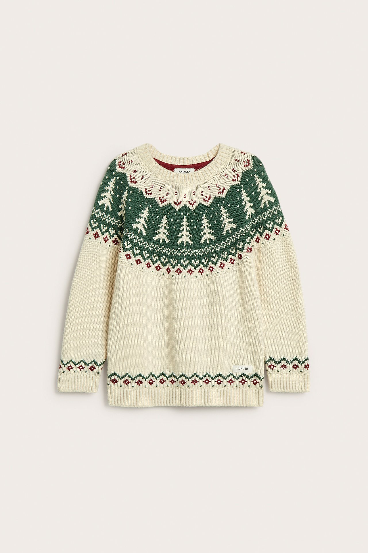 Vorderansicht eines cremefarbenen, gestrickten Baumwollpullovers mit grünen Tannenbäumen und rotem Jacquardmuster.