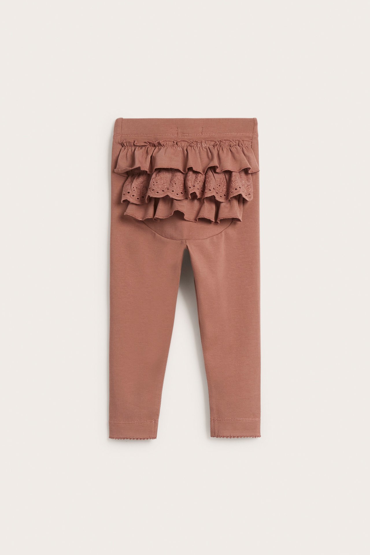 Back view of pink baby leggings with layered ruffles and a lace panel on the rear.