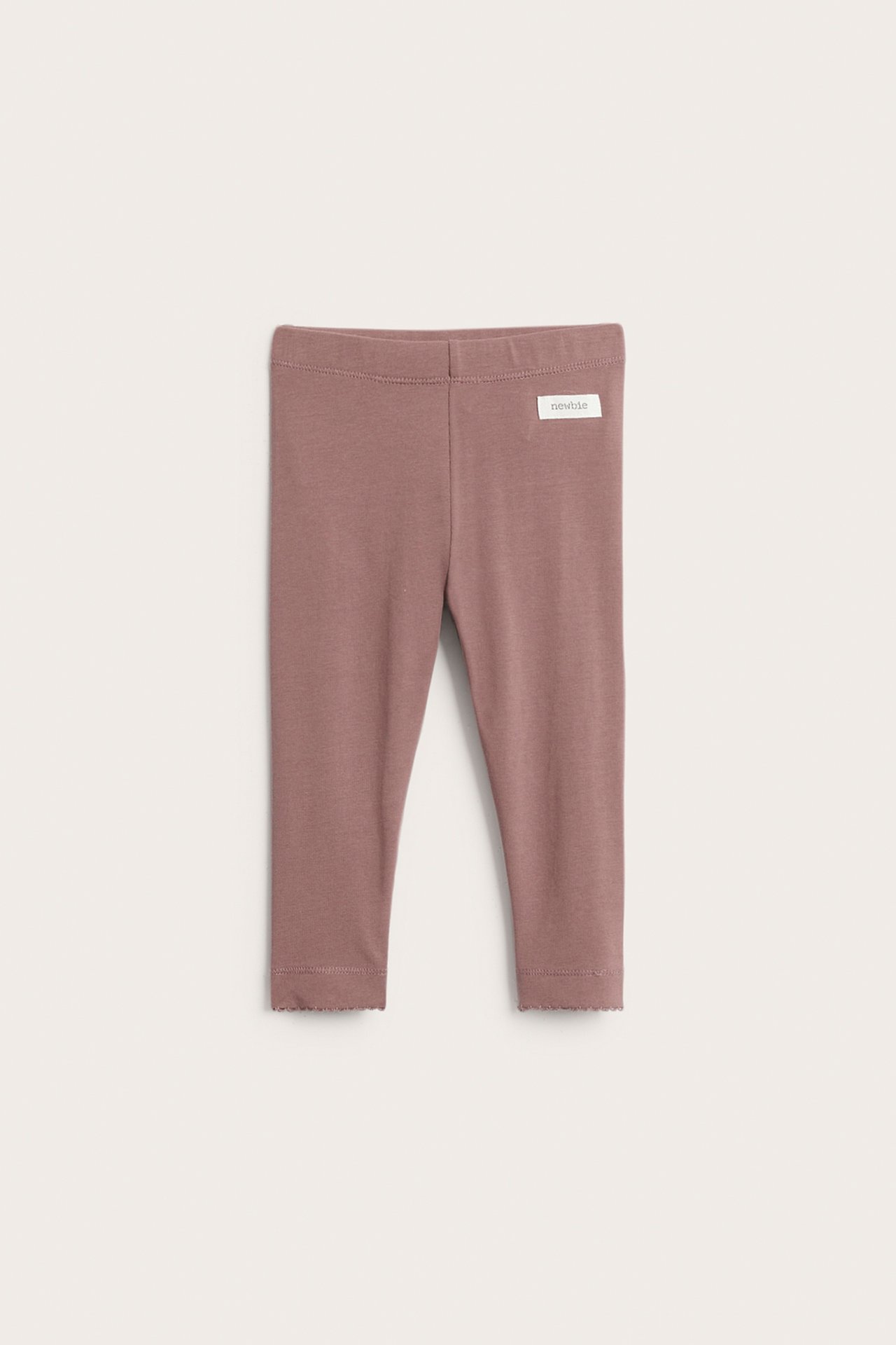 Front view of dark pink baby leggings with a plain front and scalloped hems.