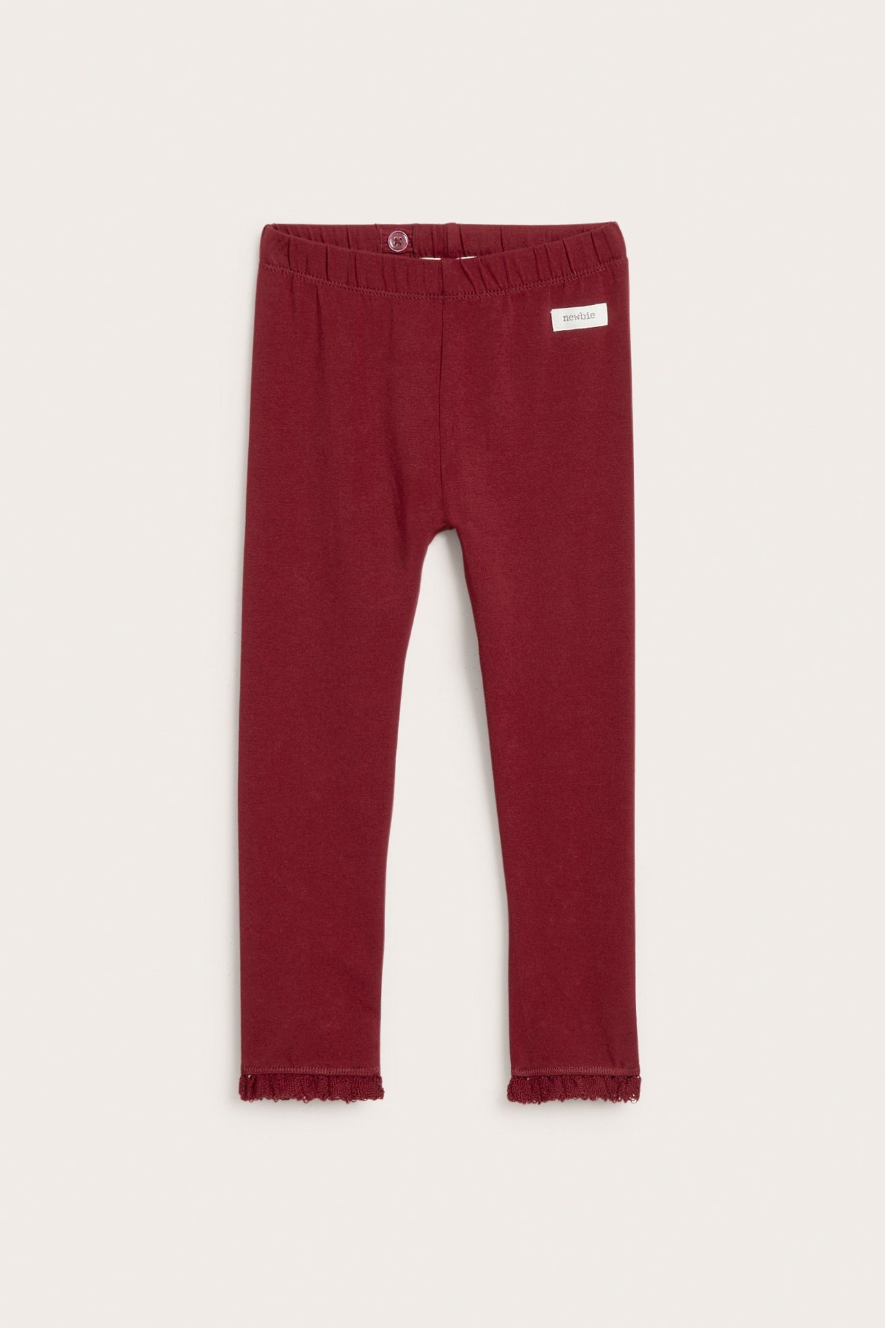 Front view of dark red kid's cotton leggings with a lace ruffle at the leg openings.