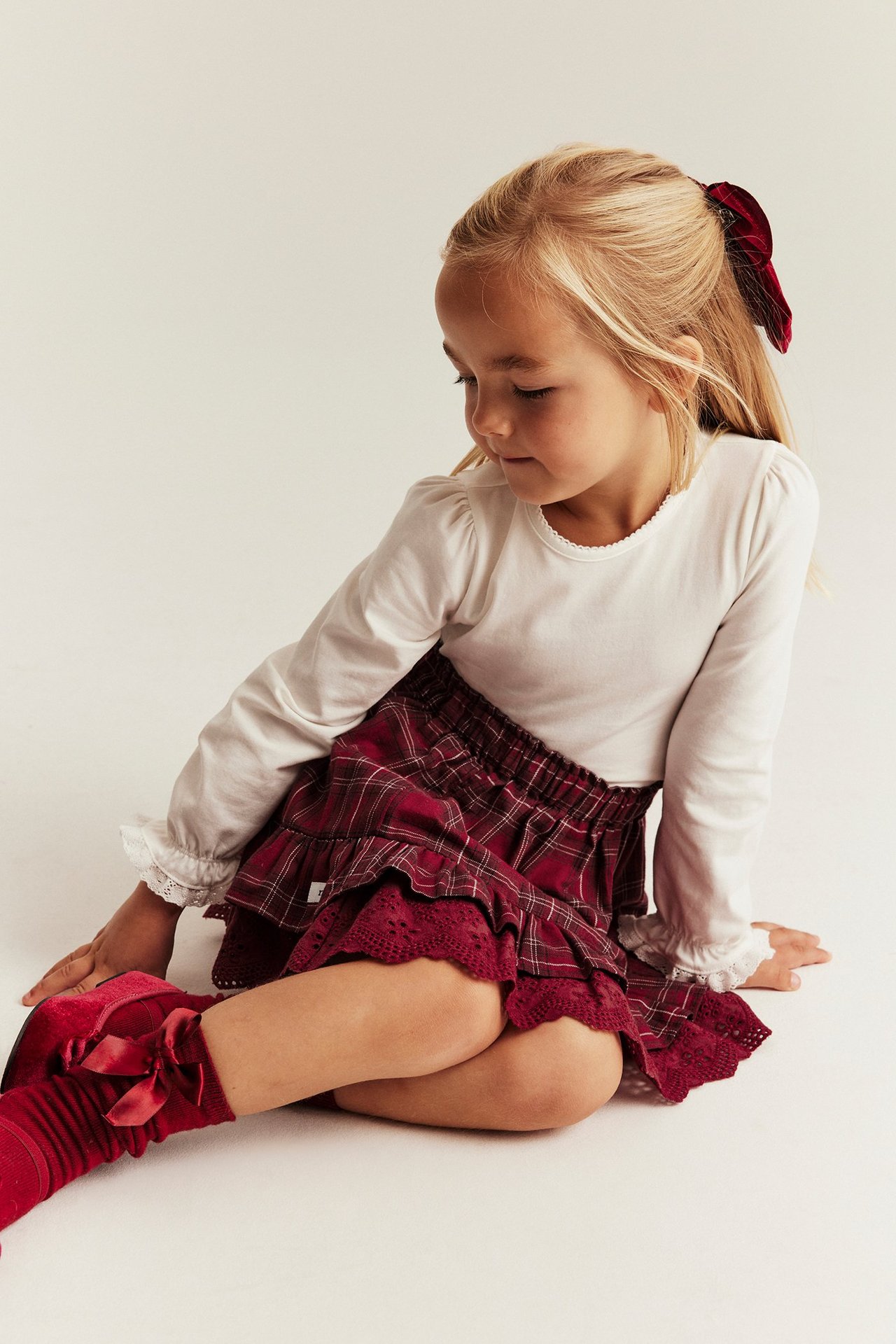 Red plaid woven skirt with frills, lace, adjustable waistband, girl, front view.