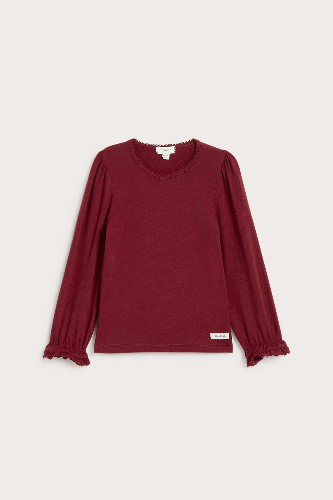 Vorderansicht: Rotes Langarmshirt für Kinder mit Picotkante am Hals und Spitzenrüschen an den Manschetten.
