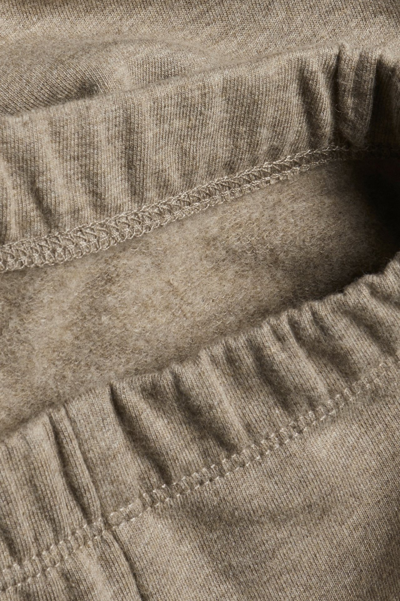 Close-up of brown melange leggings showing the elastic waistband and brushed inside.