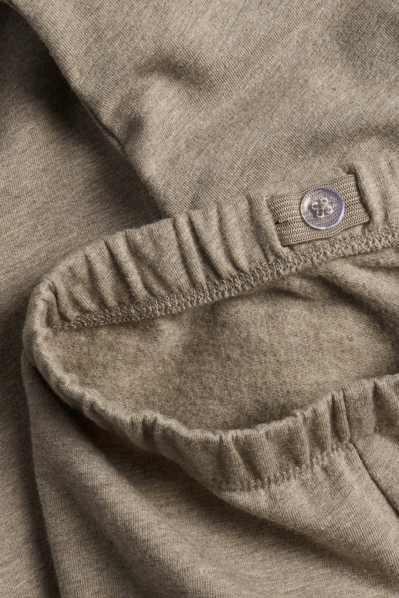 Nahaufnahme von hellbraun melierten Leggings mit elastischem, verstellbarem Bund und gebürsteter Innenseite.