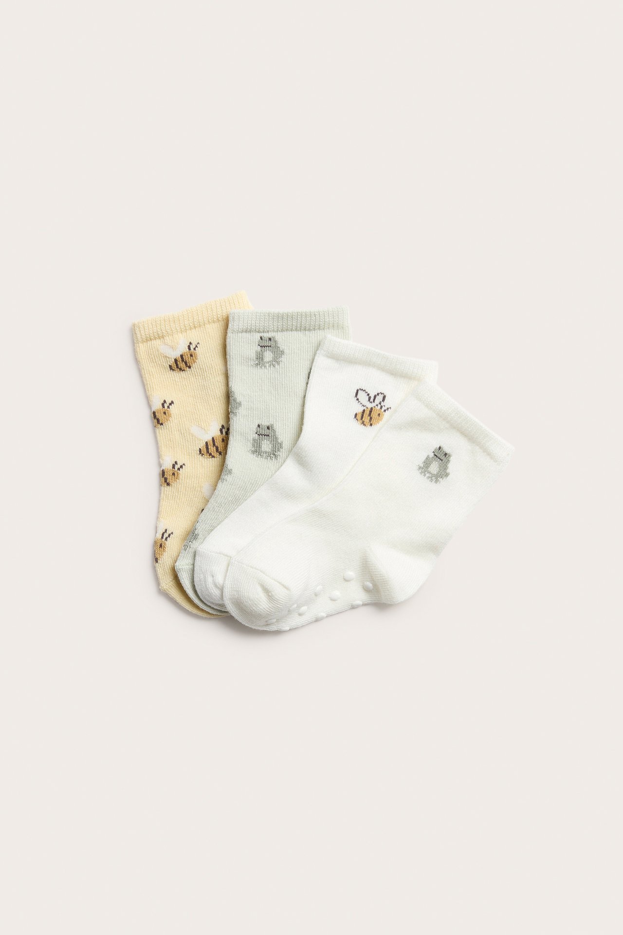 Drei Paar Babysocken: gelb mit Bienen, hellgrün mit Fröschen und cremeweiß mit Antirutsch-Sohlen.