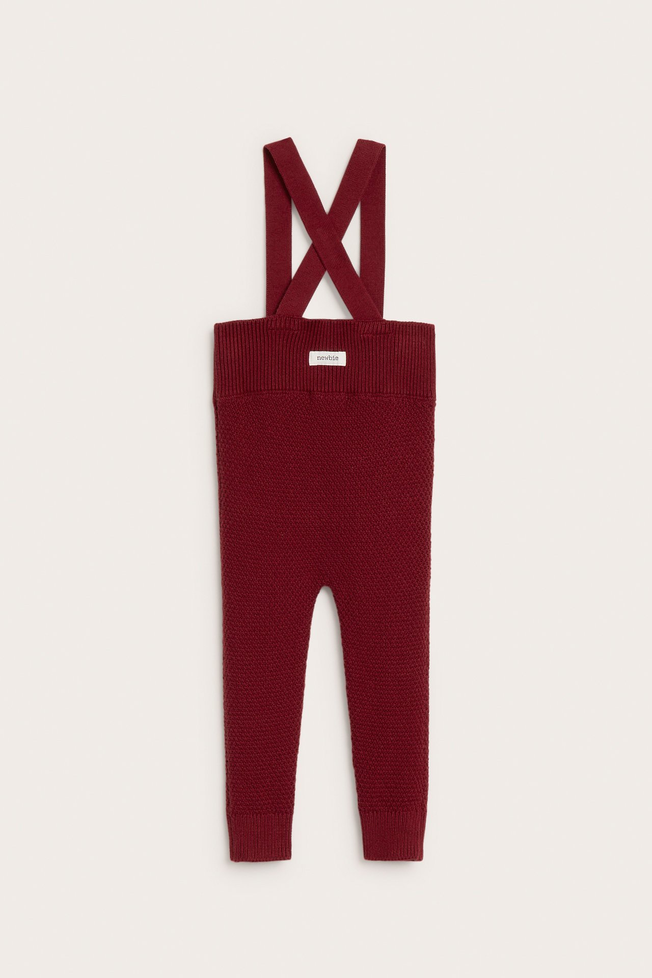 Vorderansicht von roten, strukturgestrickten Baby-Latzhosen mit verstellbaren Trägern, Rippbündchen an Taille und Bein.