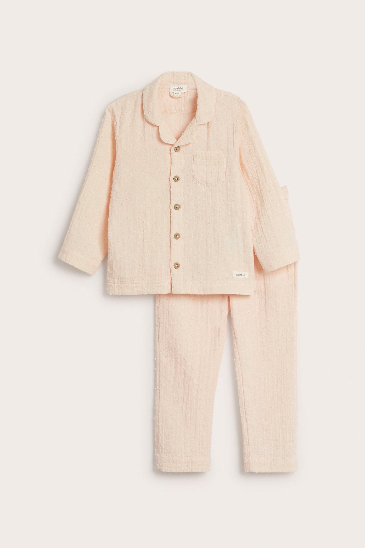 Front view of a kid's light orange dotted cotton pajama set with a collared shirt and matching pants.