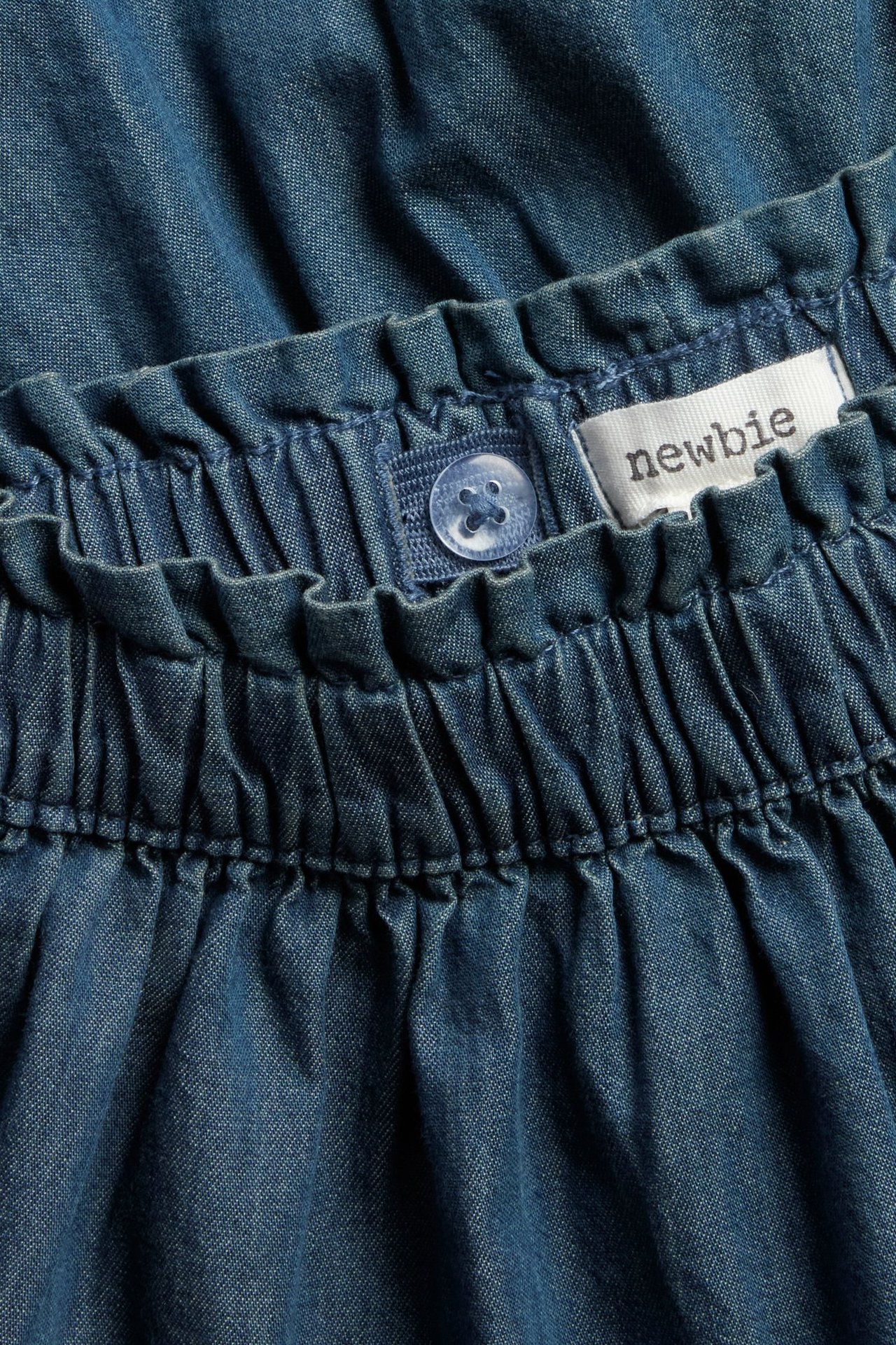 Dark blue denim skirt with ruffles at hem, adjustable waist elastic, side pockets, kid.