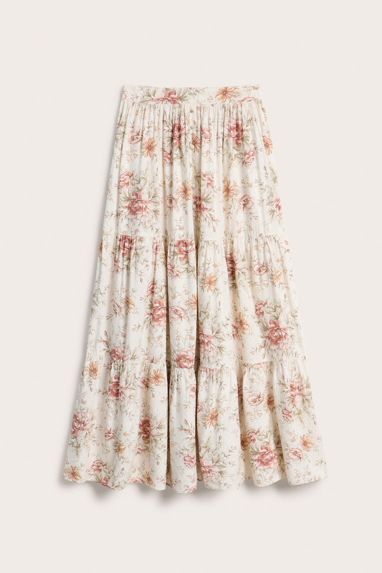 Front view of an off-white floral tiered maxi skirt in viscose with covered buttons and elasticated waist.