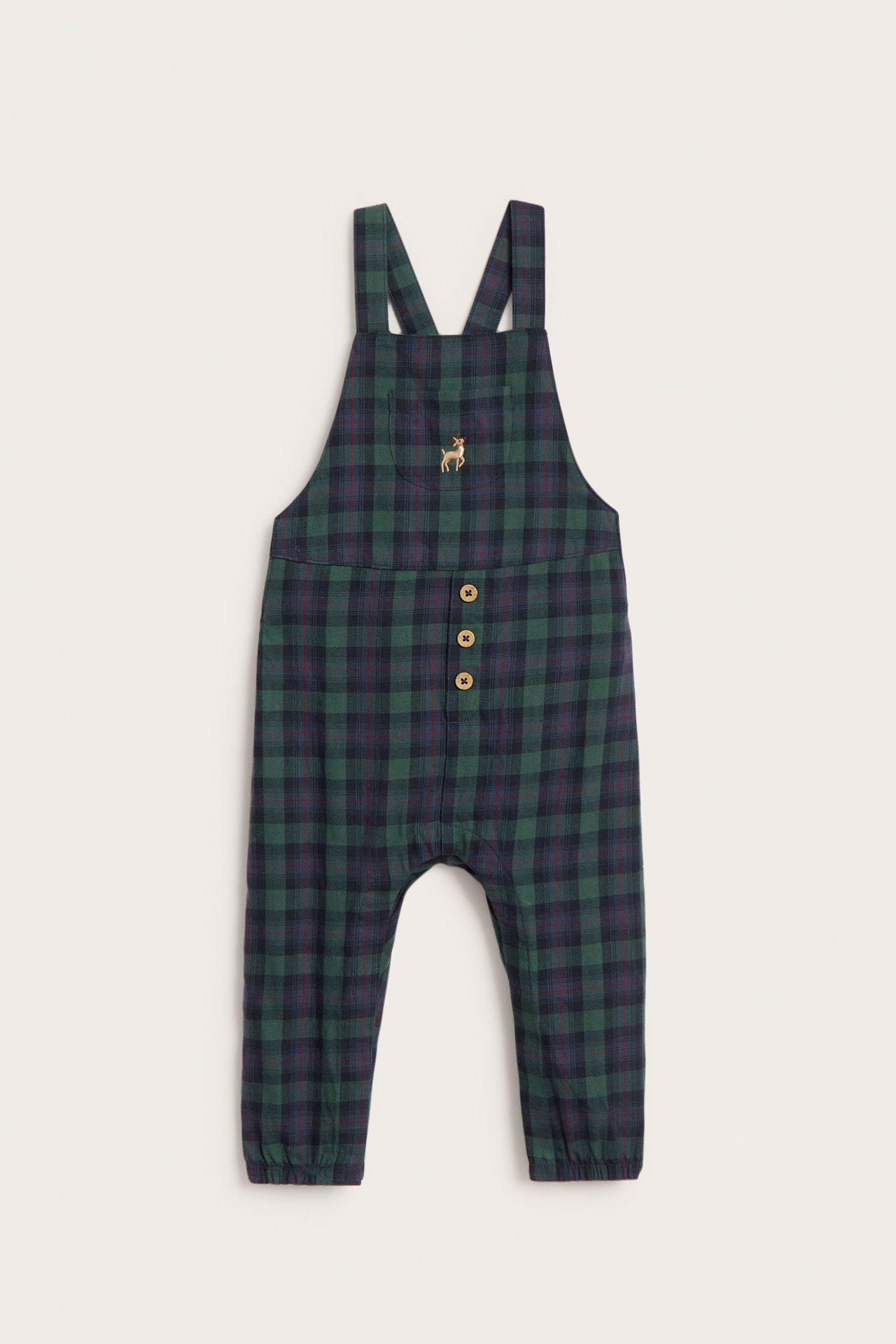 Vorderansicht von Baby-Latzhose aus dunkelgrüner, blau karierter Baumwolle mit Holzknöpfen und Hirschstickerei.