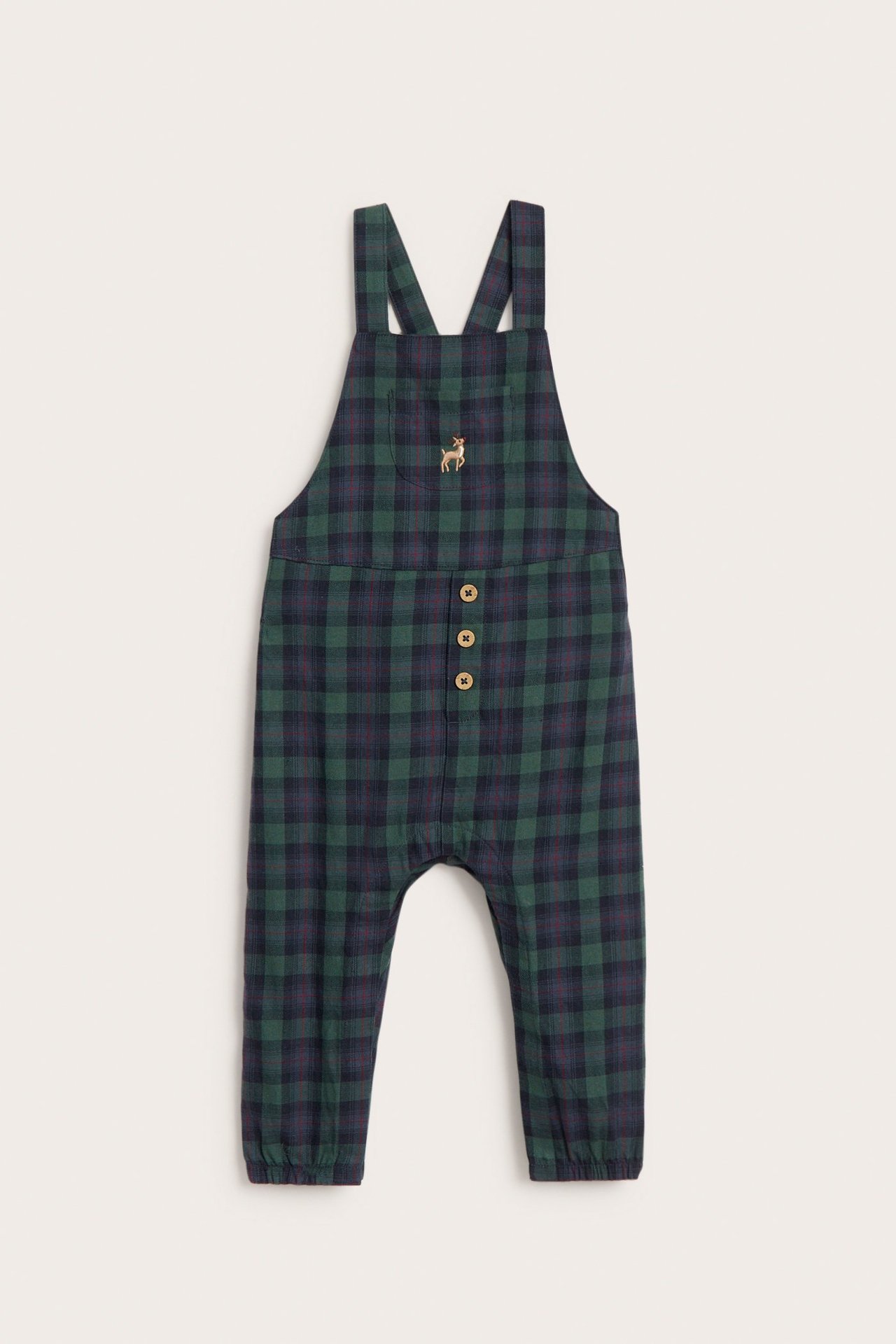 Vorderansicht von Baby-Latzhose aus dunkelgrüner, blau karierter Baumwolle mit Holzknöpfen und Hirschstickerei.