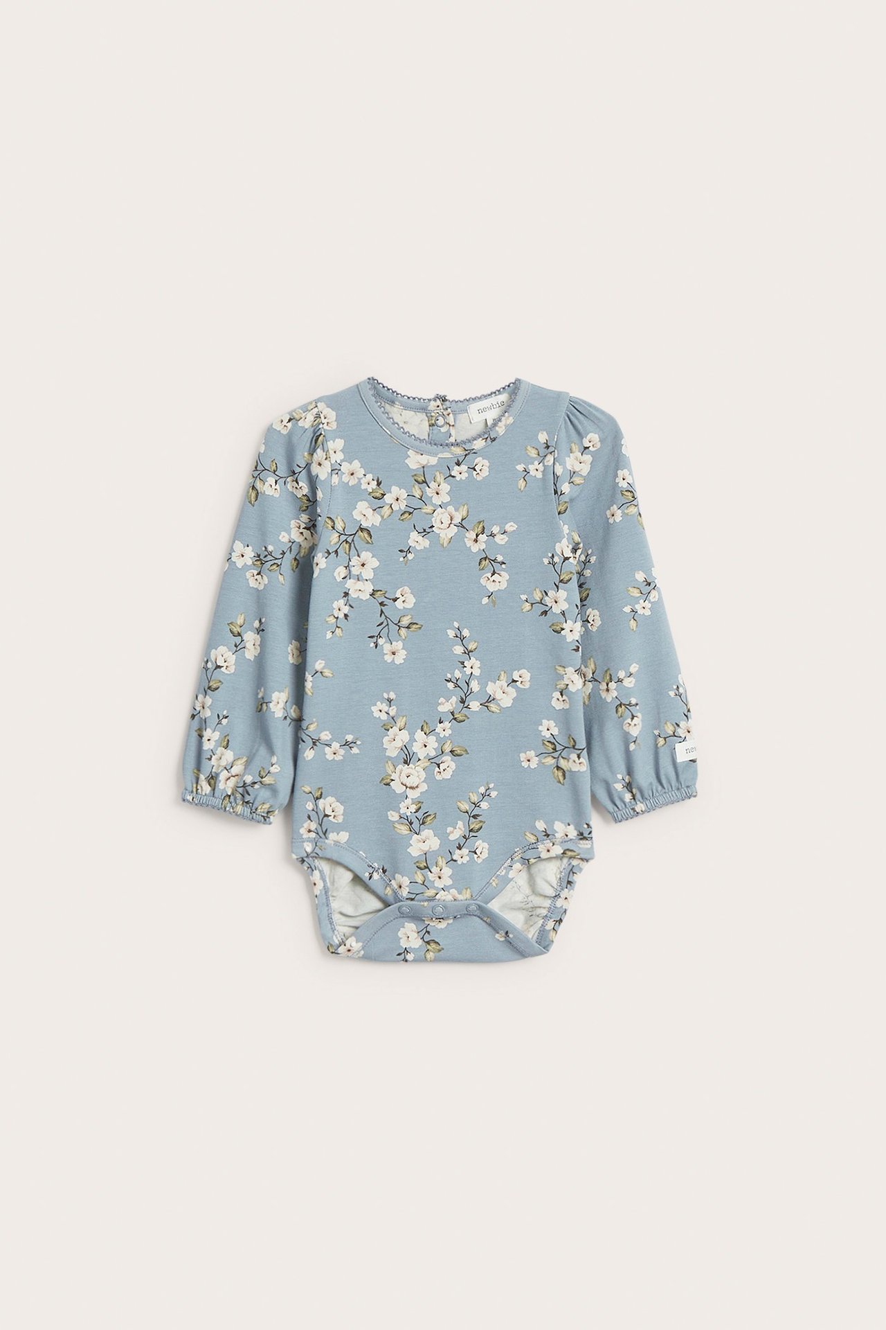 Front view of a baby's light blue floral long-sleeved bodysuit with puff sleeves and picot trim.