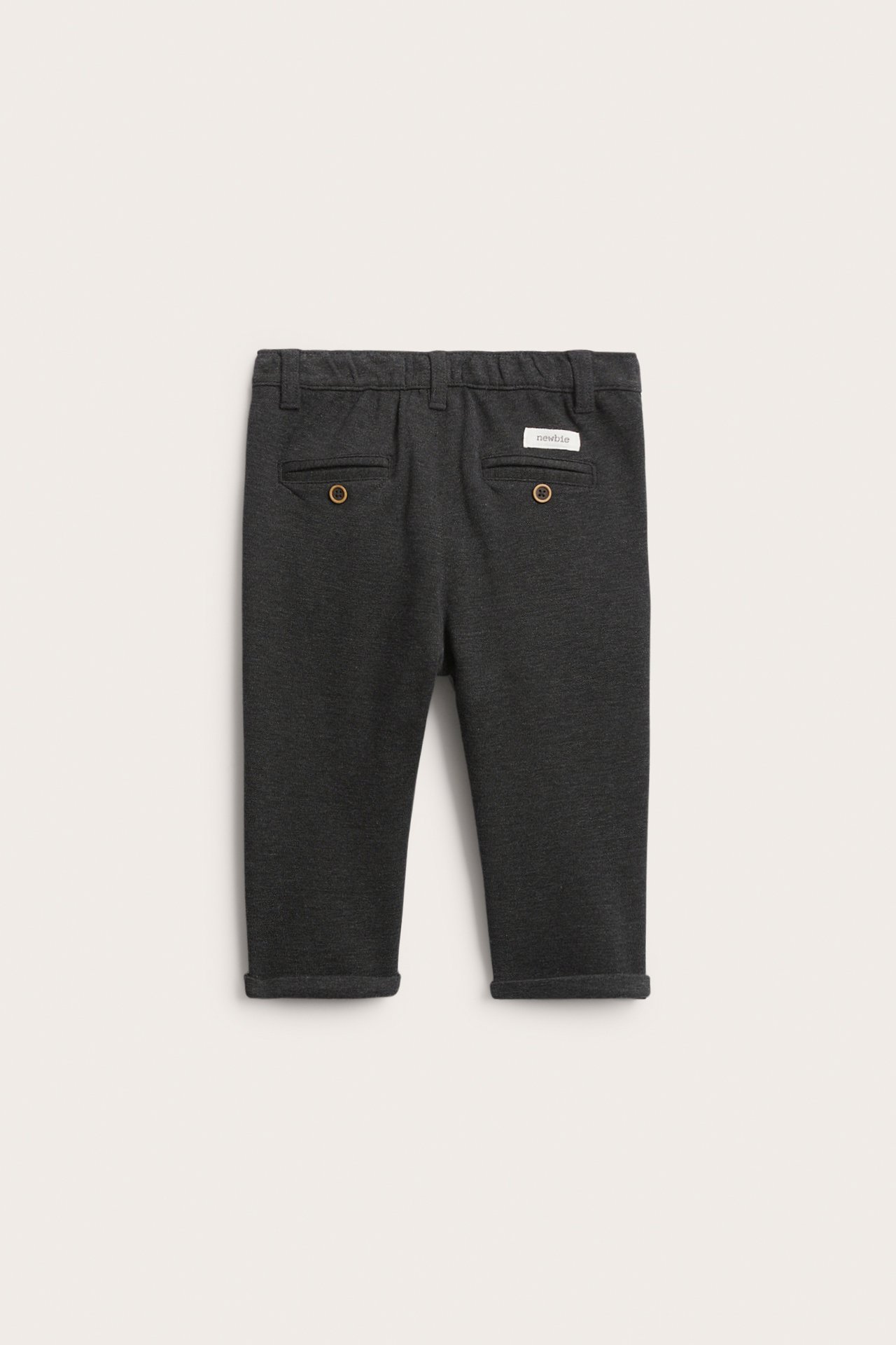 Rückansicht einer dunkelgrauen Kinder-Strickhose mit zwei geknöpften Gesäßtaschen und umgekrempelten Bündchen.