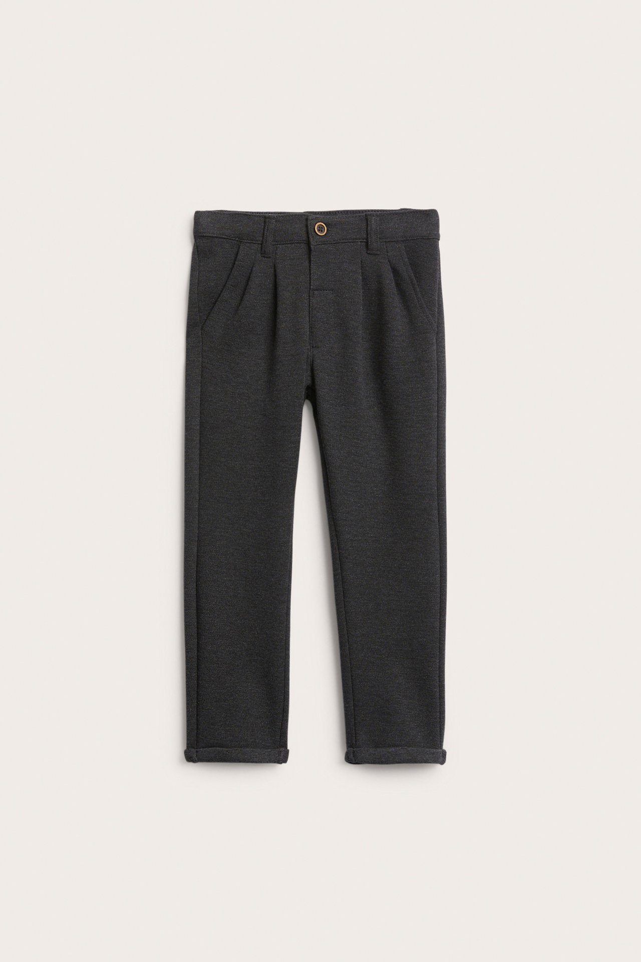 Vorderansicht einer dunkelgrauen Kinderhose mit Knopfverschluss, Falten und Krempen.
