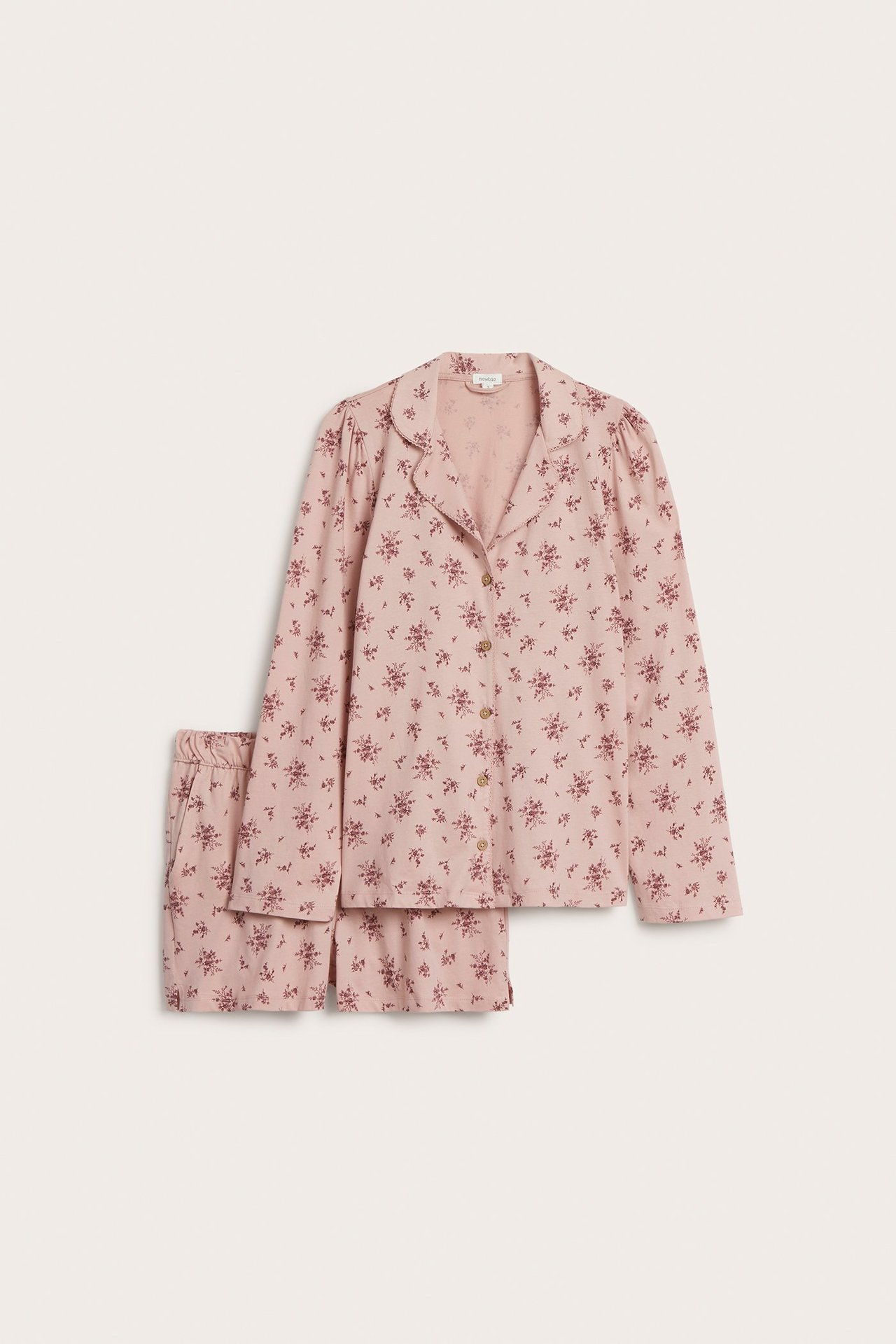 Vorderansicht eines rosa geblümten Baumwoll-Pyjama-Sets mit langärmligem Knopf-Oberteil und passenden Shorts.