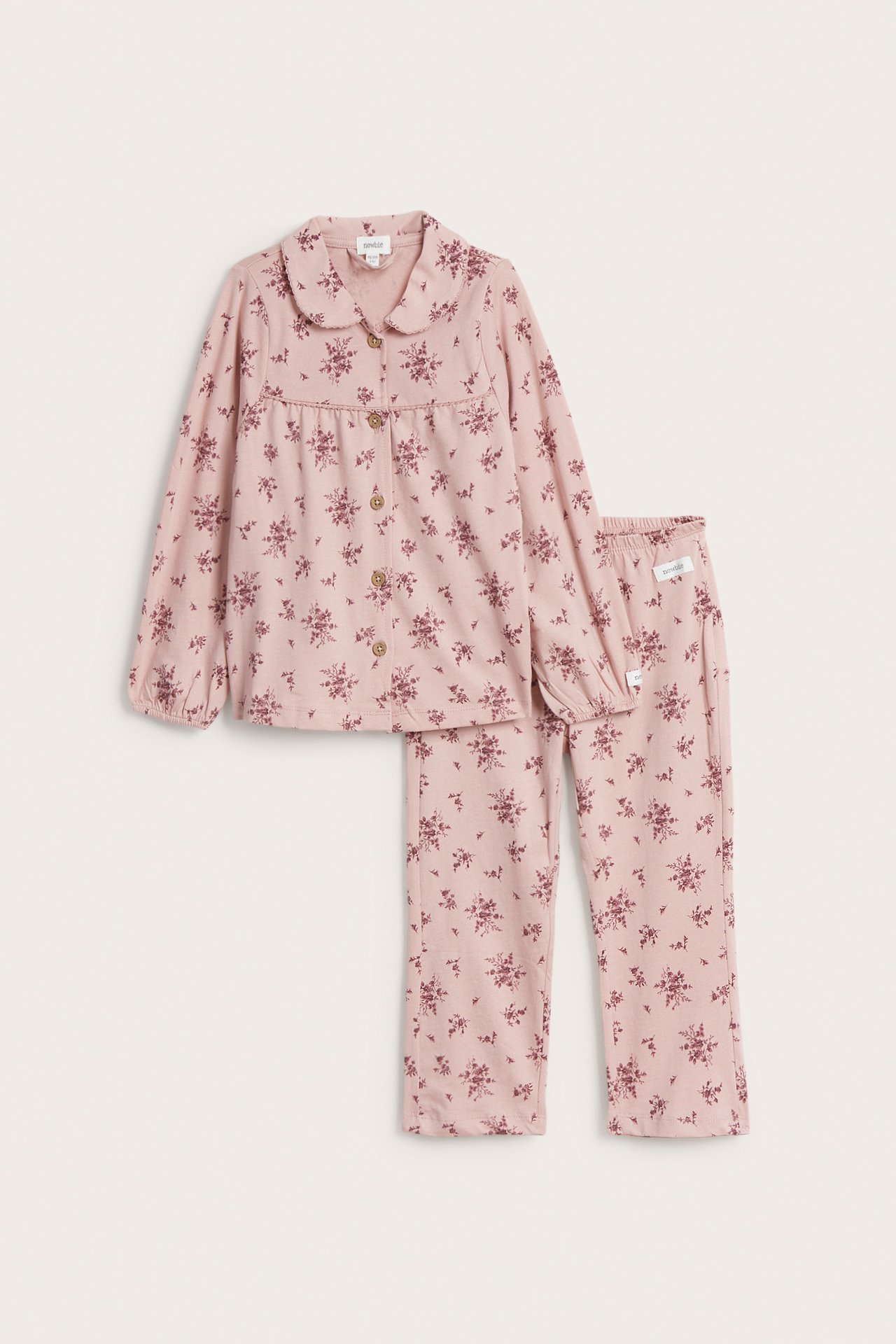 Vorderansicht eines rosa geblümten Baumwollpyjamas mit Kragen, Knopfleiste vorne und passender Hose.
