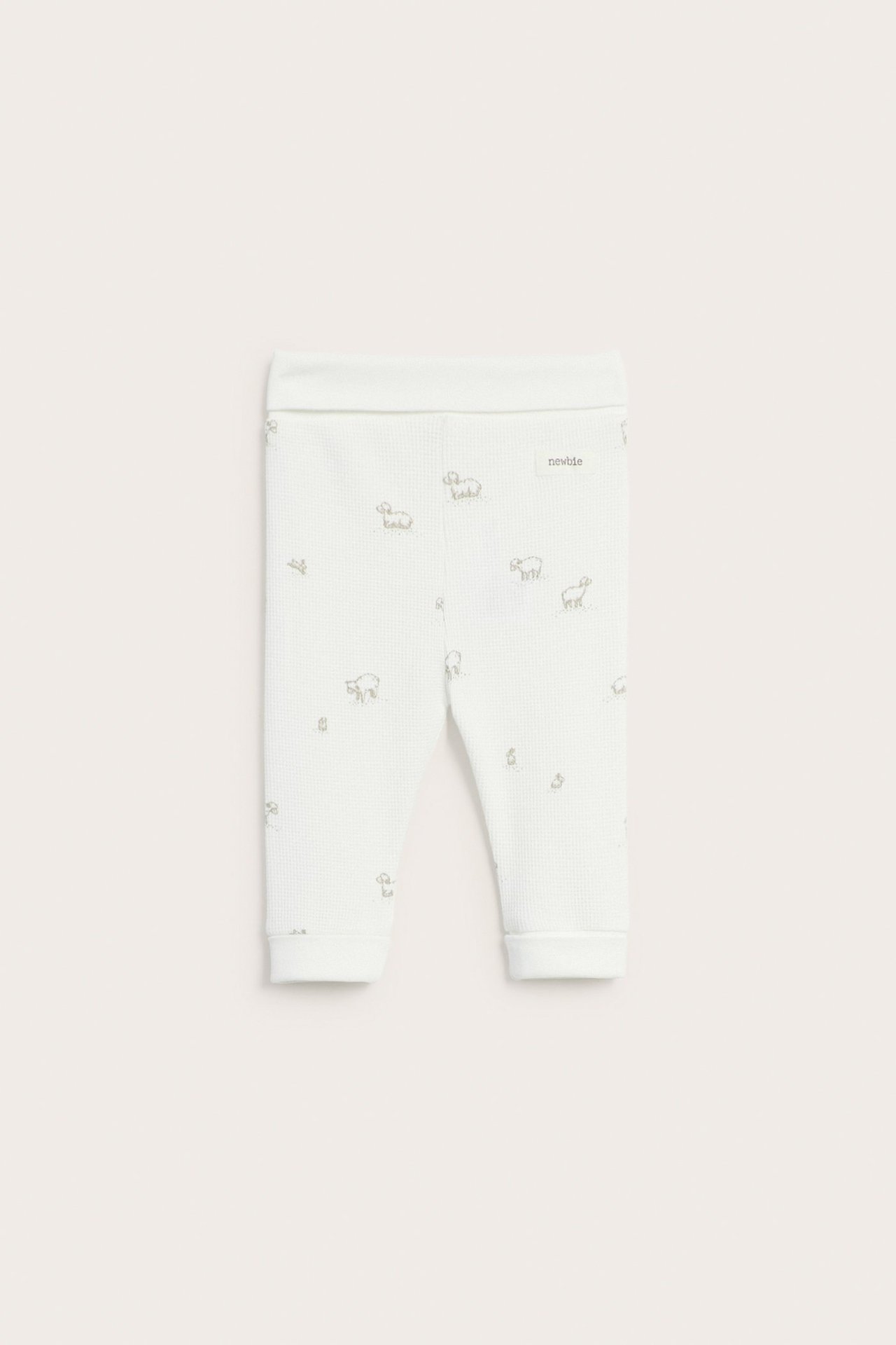 Vorderansicht von cremeweißen Baby-Leggings mit Waffelstruktur, dezentem Lamm-Muster und Bündchen.