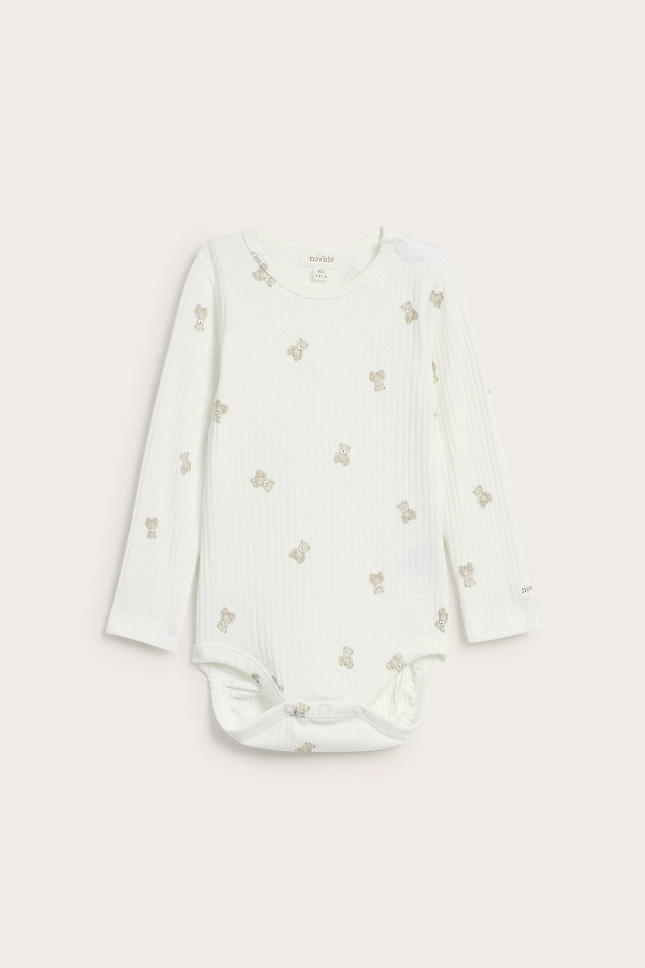 Vorderansicht eines cremefarbenen gerippten Baby-Bodys mit langen Ärmeln und Teddybärmuster, mit Druckknöpfen.