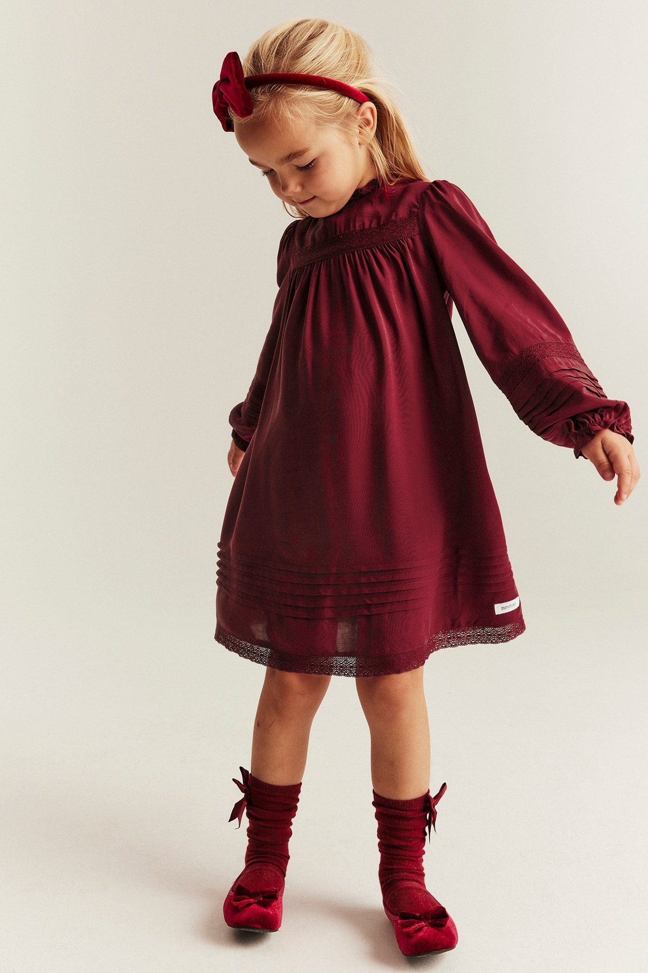 Red viscose dress for kids, lace details, pintucks, elastic with frill in sleeve opening.