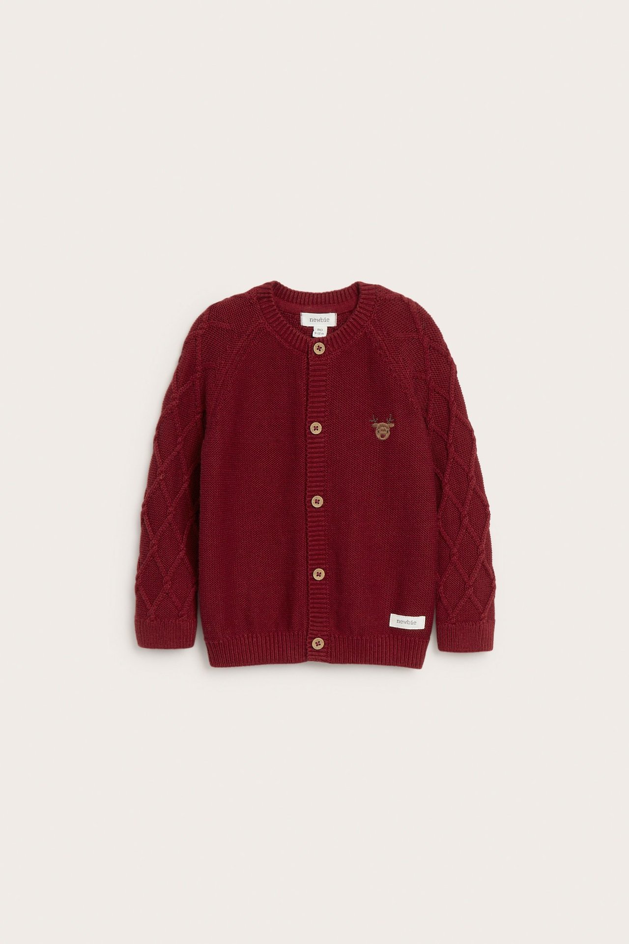 Front view of a kid's red knitted cotton cardigan with button front, patterned sleeves, and reindeer embroidery.