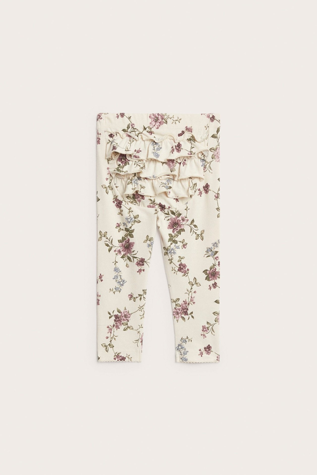 Vorderansicht von hellbeigen Kinder-Leggings mit Blumenmuster, Rüschen hinten und elastischem Bund.