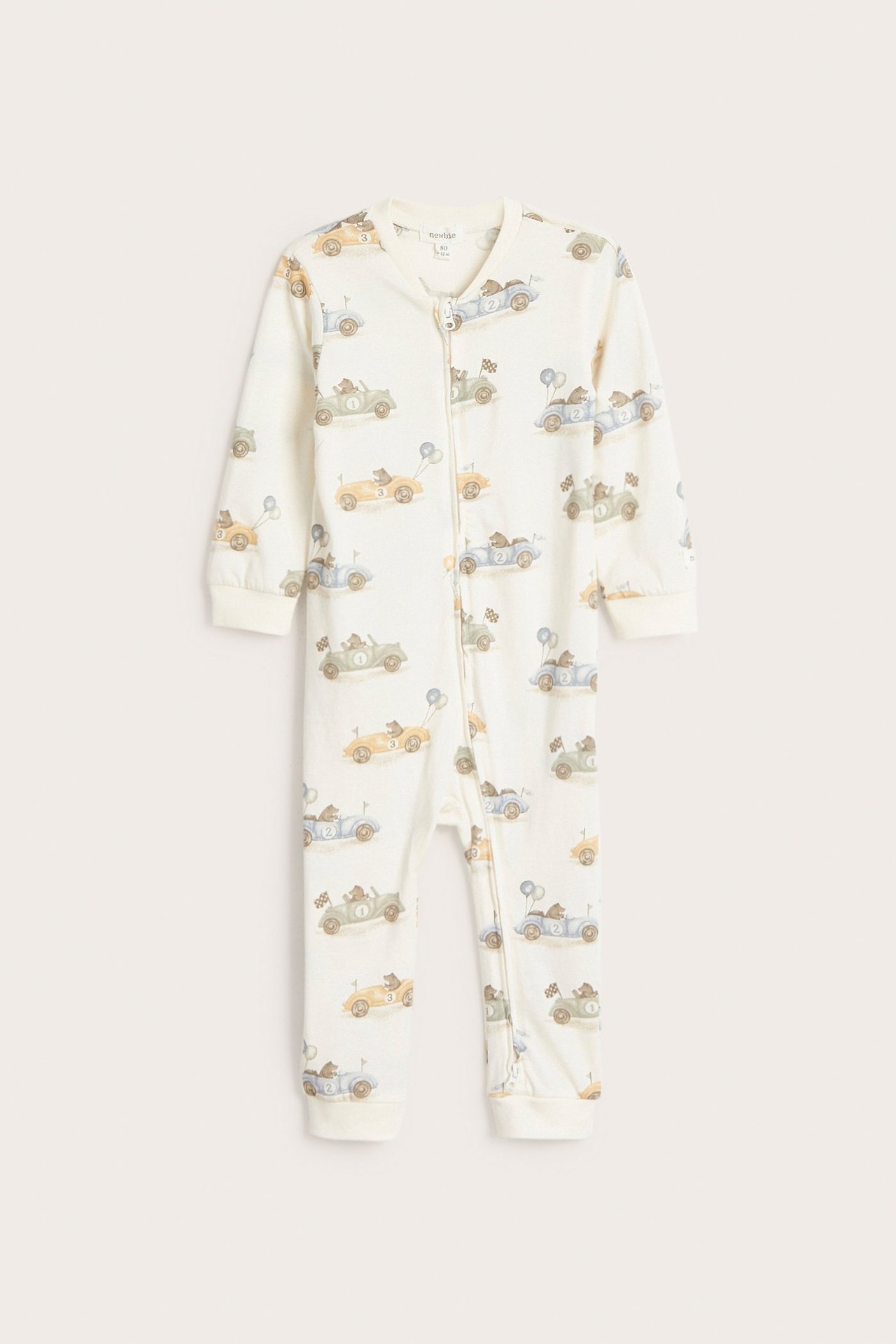 Front view of an off-white baby's jersey pajama with a bear and car pattern, with a two-way zipper.