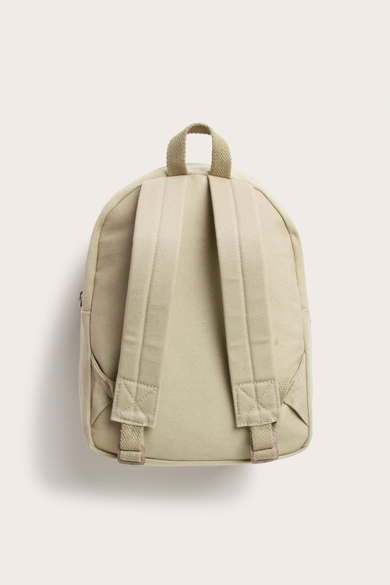 Rückenansicht eines beigen Rucksacks aus Baumwoll-Canvas mit verstellbaren Schultergurten und Tragegriff.