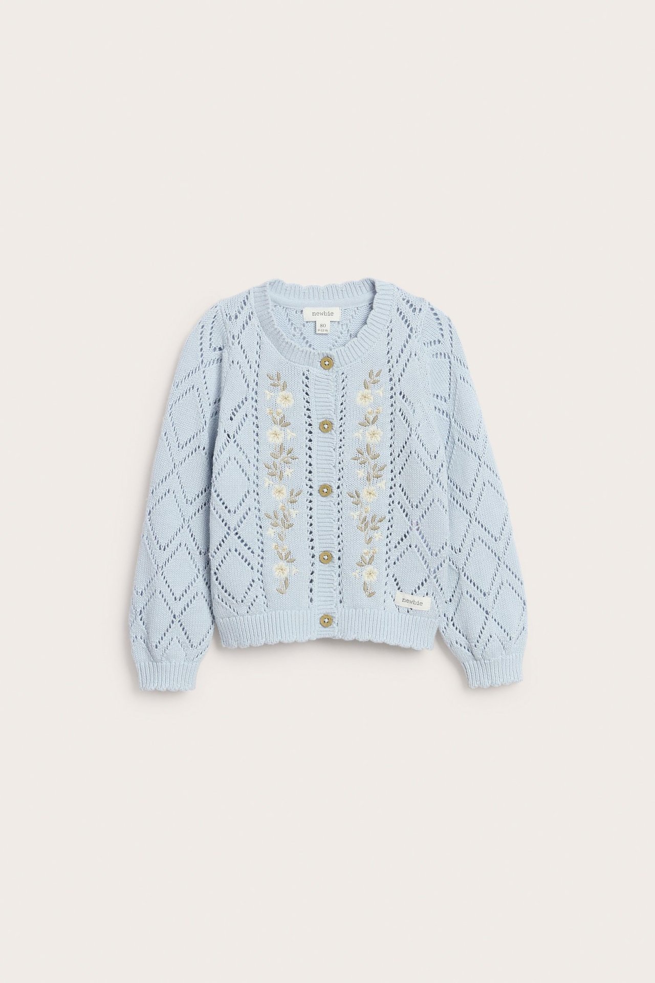 Front view of a light blue knitted kid's cardigan with white flower embroidery and diamond pattern, button-front.