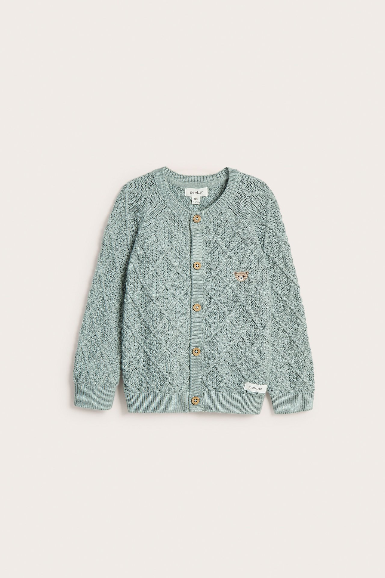 Front view: Light green knitted baby cardigan with diamond pattern, wooden buttons, and small bear embroidery.