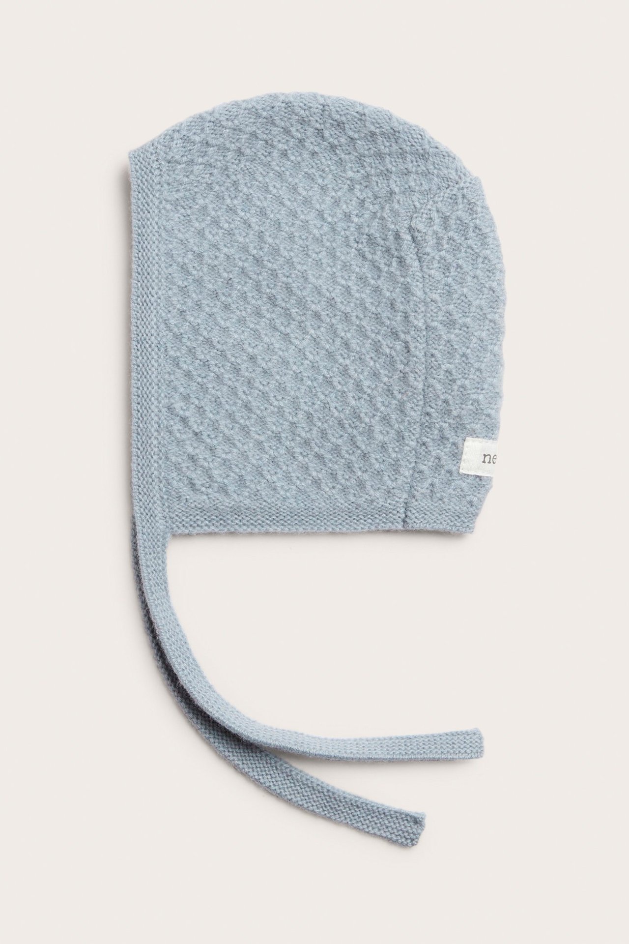 Front view of a light blue baby bonnet in a textured knit wool-cashmere blend with tie bands.