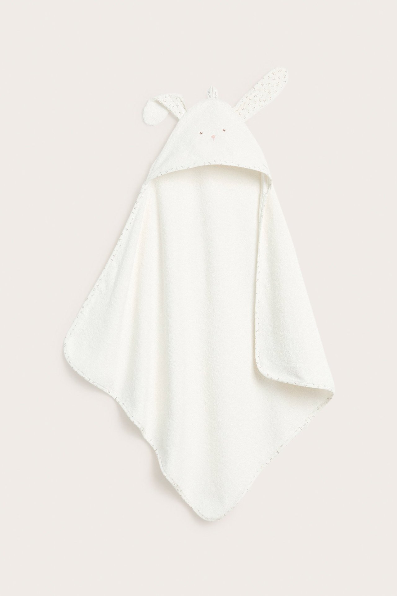 Front view: Off-white baby hooded terry towel with rabbit ears and embroidered face details.