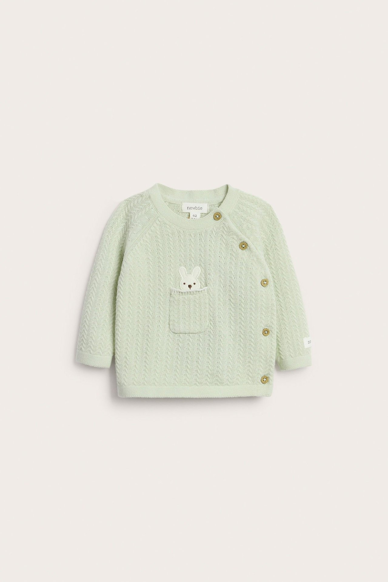 Front view of a light green structured knit baby cardigan with bunny embroidery pocket and side button fastening.