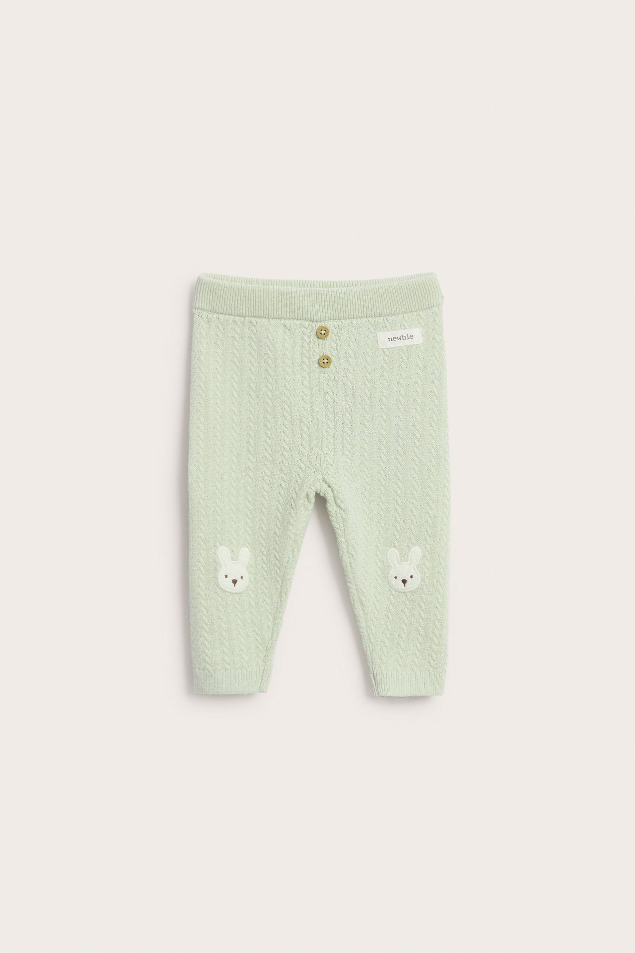 Vorderansicht: Hellgrüne Baby-Strickleggings mit Zierknöpfen und weißen Hasenapplikationen an den Knien.
