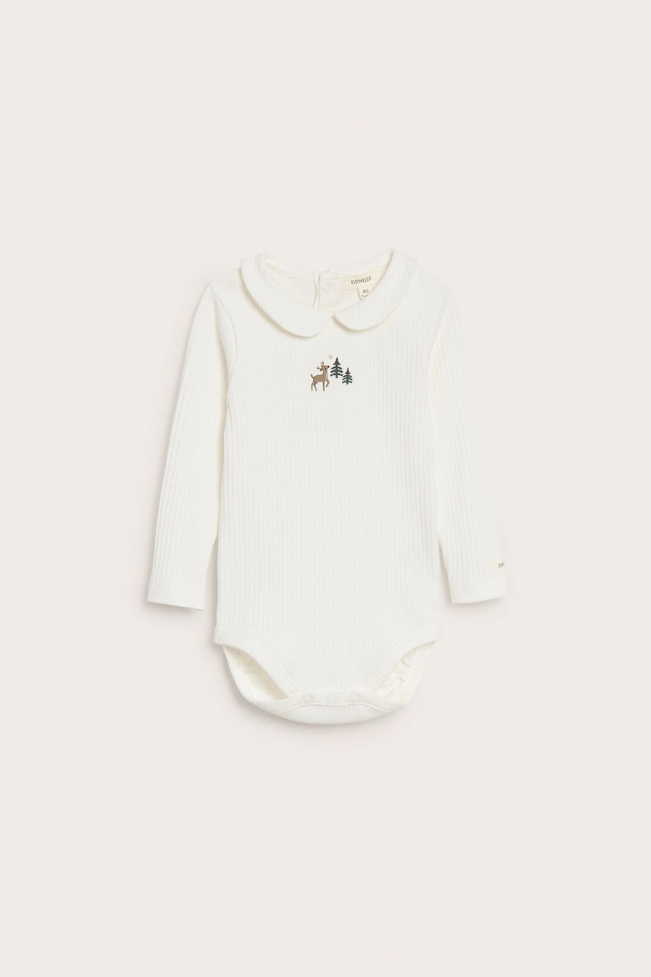 Front view of an off-white ribbed baby bodysuit with a round collar and reindeer and tree embroidery.