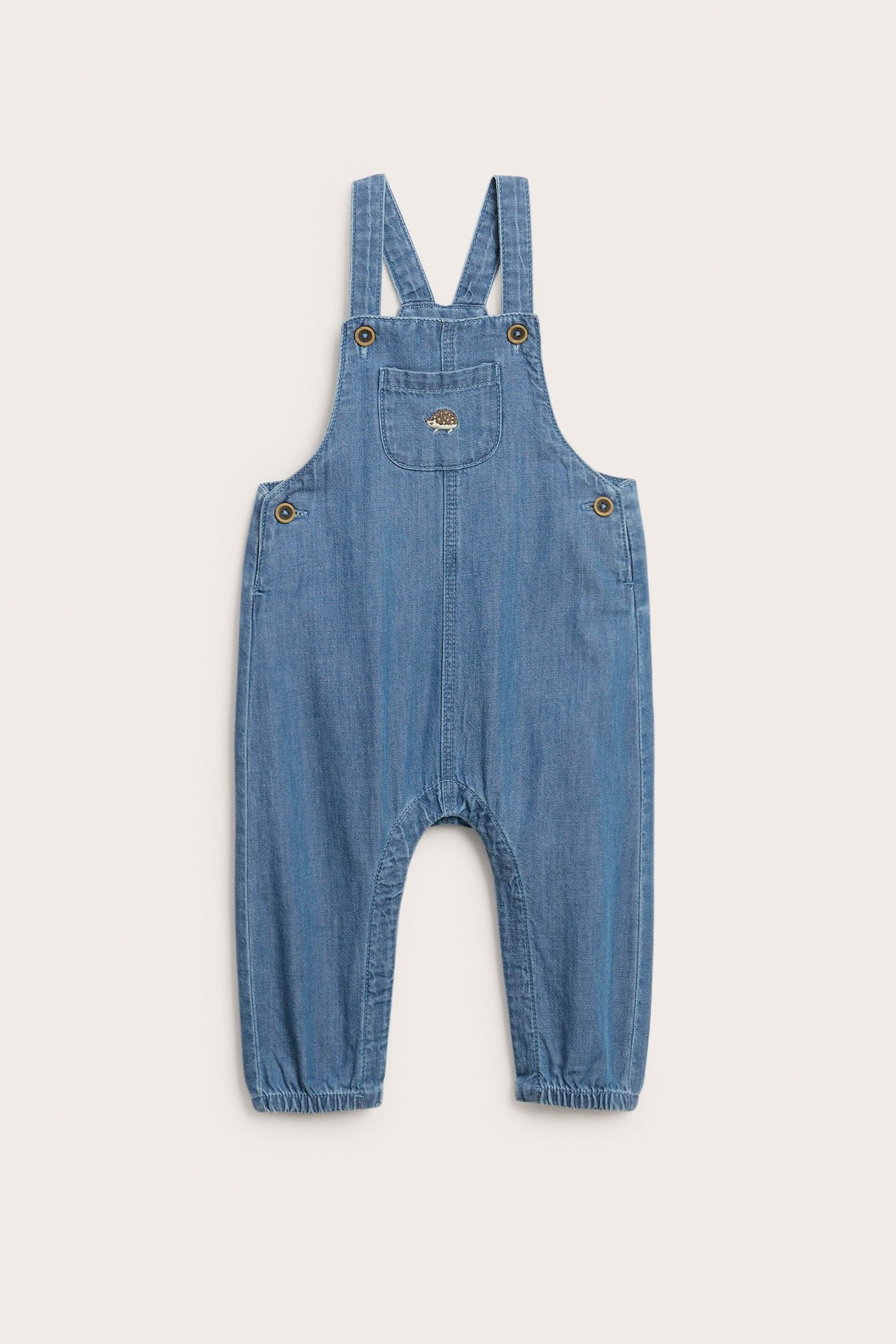 Vorderansicht von Baby-Latzhosen aus hellblauem Denim mit Igel-Stickerei, verstellbaren Trägern, Seitenknöpfen und elastischen Bündchen.